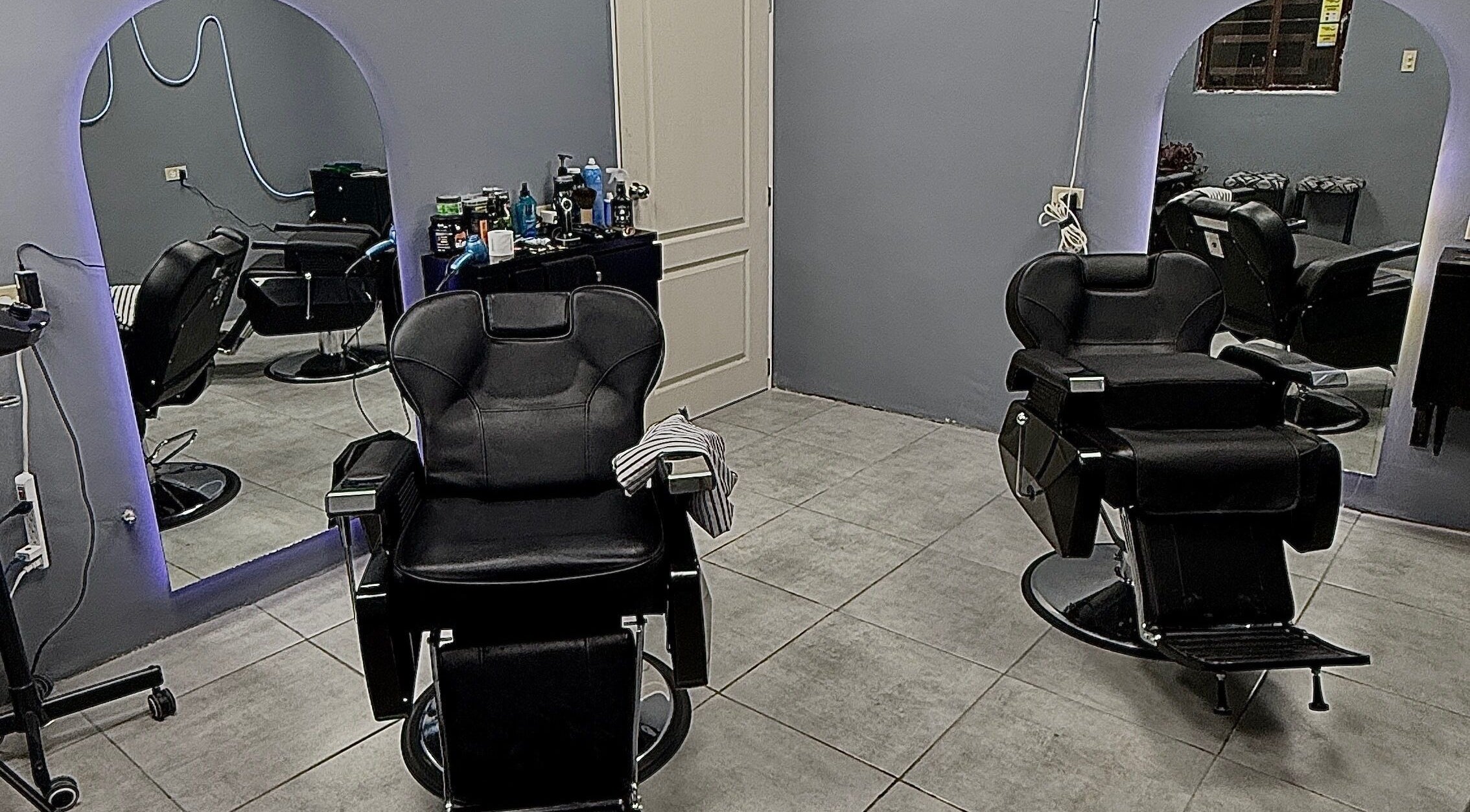 Interior del Mucho Pelo Barber Studio en Juárez, Chihuahua, MX, mostrando sillones de barbería modernos.