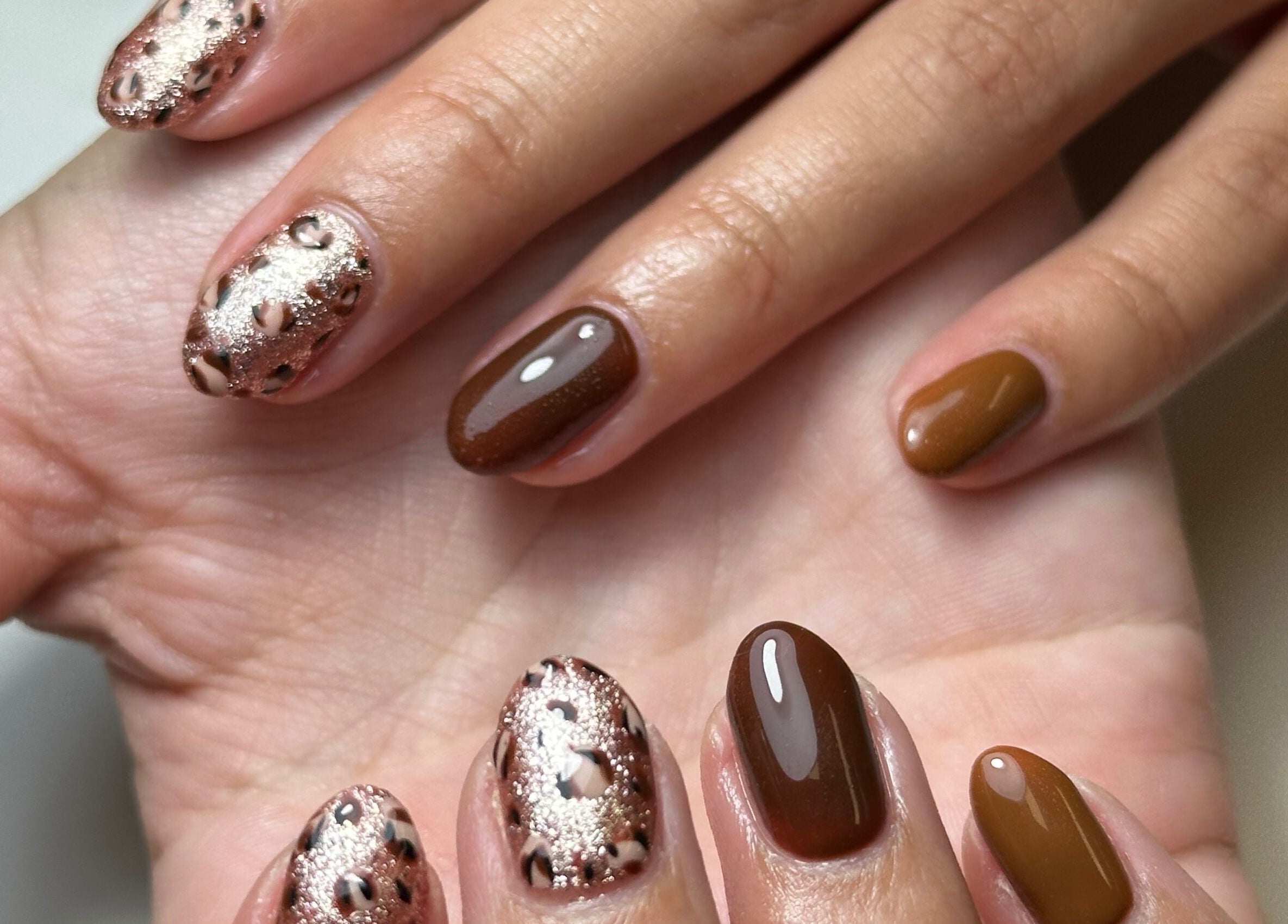 Chic nail art at Beauty Box Spa, Bracknell, England, GB showcases glitter and brown polish.
