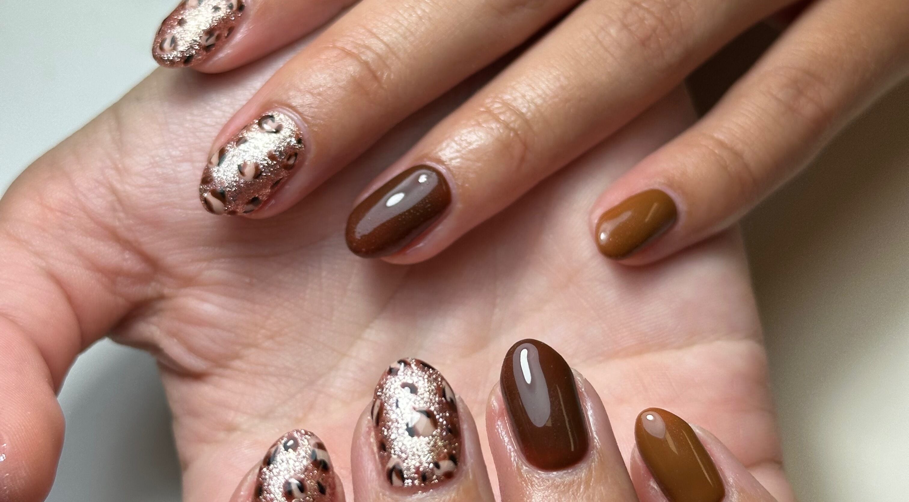 Chic nail art at Beauty Box Spa, Bracknell, England, GB showcases glitter and brown polish.