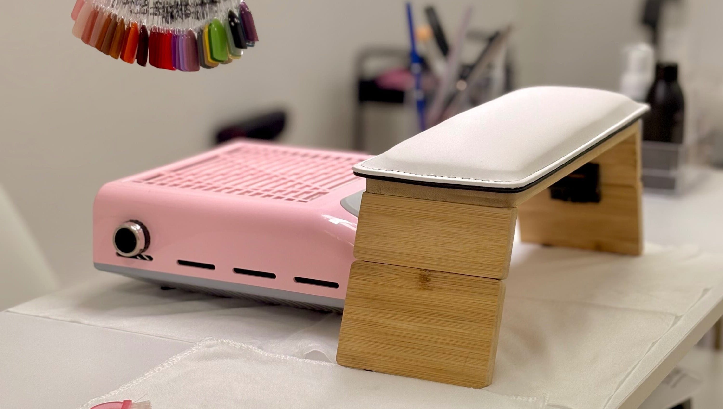 Mesa de manicura en Nails by Angie, Barcelona, Catalunya, ES, con lámpara UV y muestra de colores de esmalte.