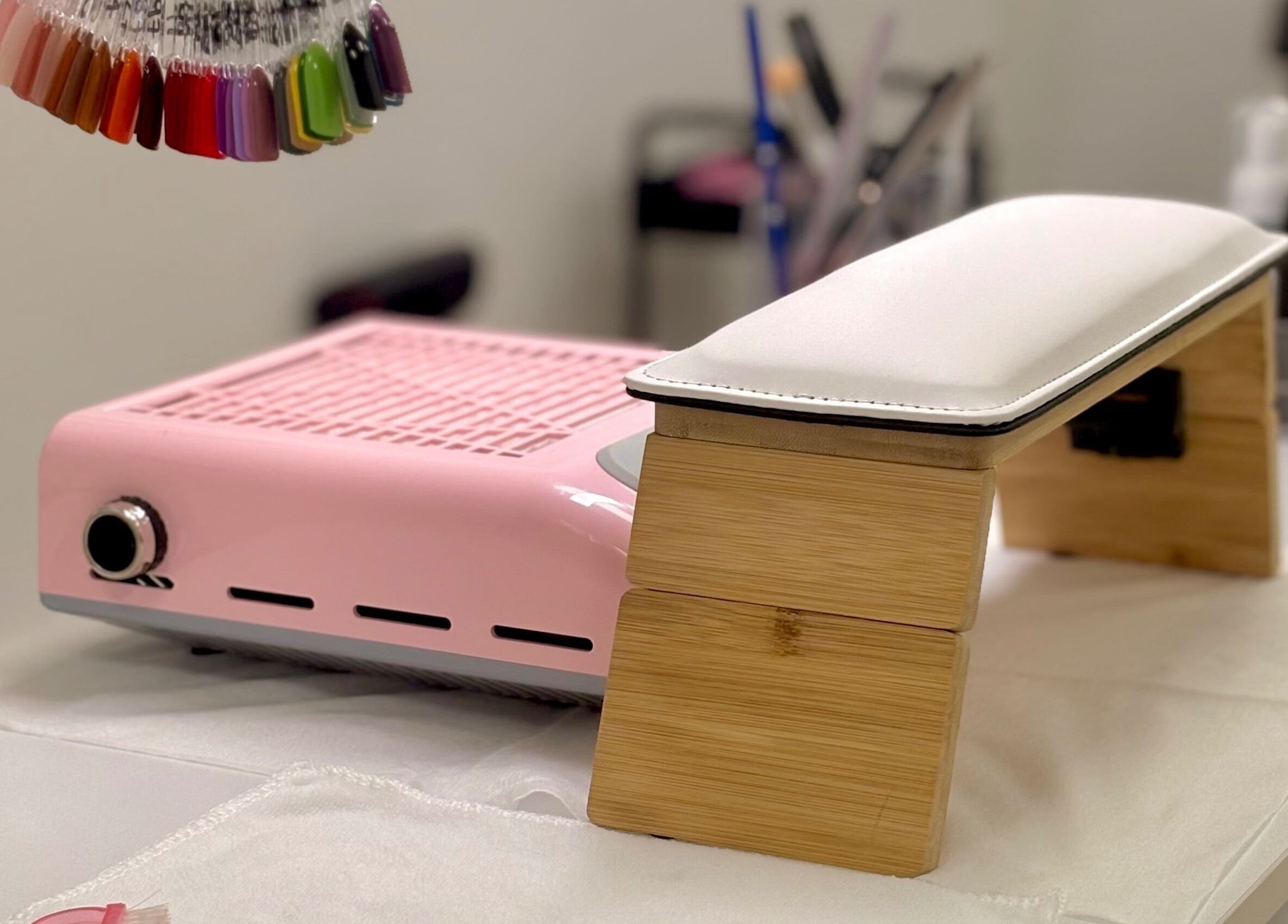 Mesa de manicura en Nails by Angie, Barcelona, Catalunya, ES, con lámpara UV y muestra de colores de esmalte.