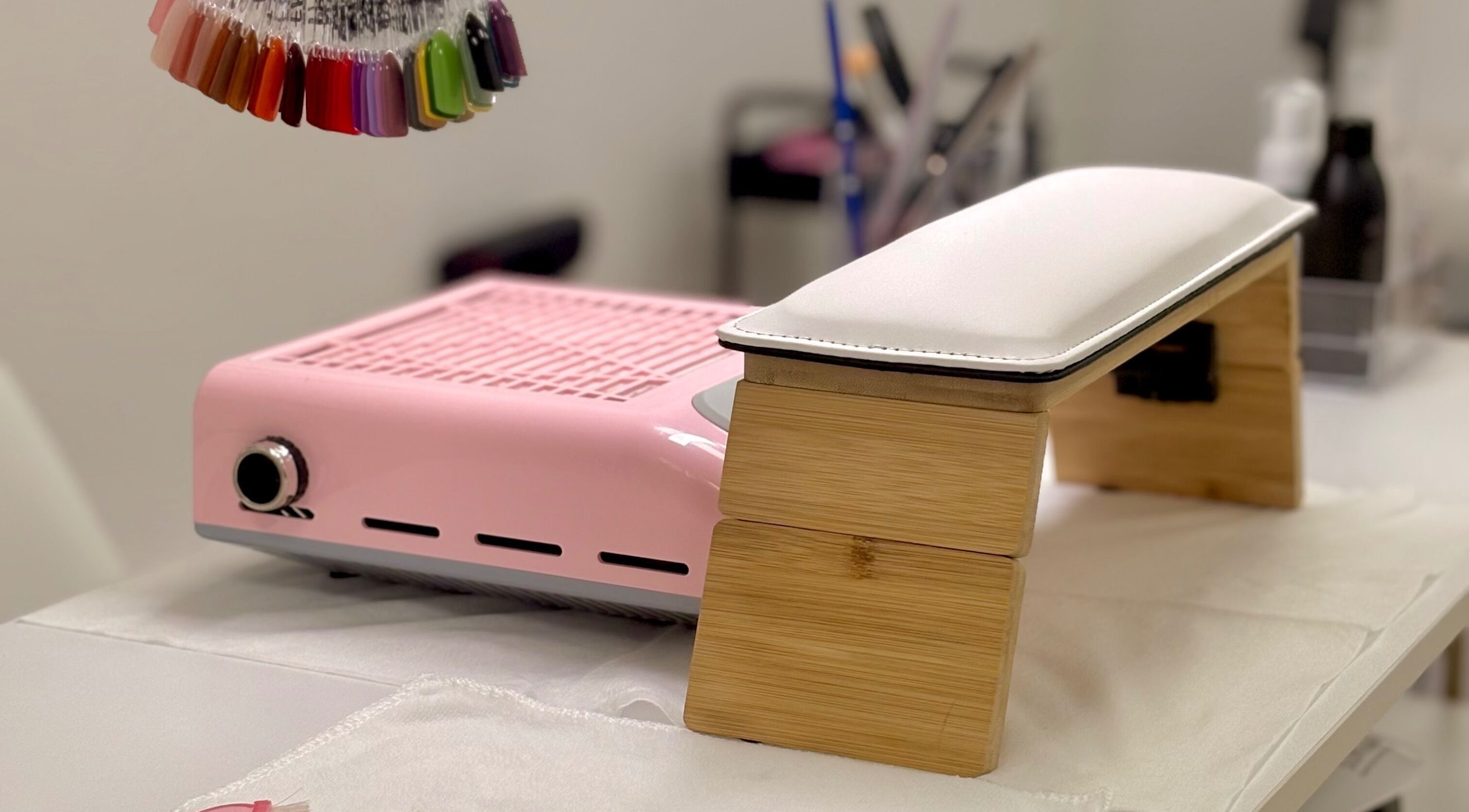 Mesa de manicura en Nails by Angie, Barcelona, Catalunya, ES, con lámpara UV y muestra de colores de esmalte.