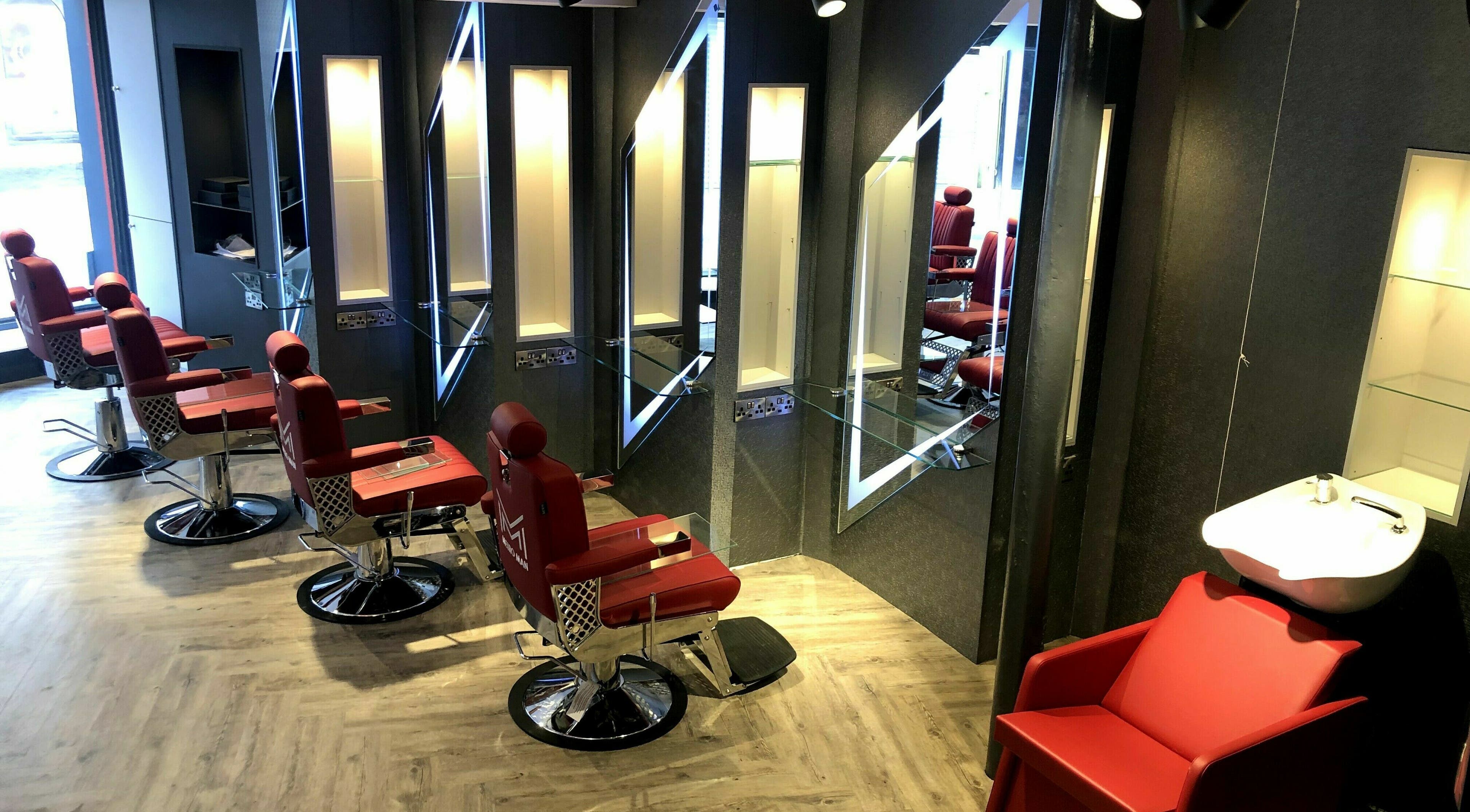 Red barber chairs and mirrors at Metro Man Barbers in Cork, County Cork, IE offer a sleek, modern look.