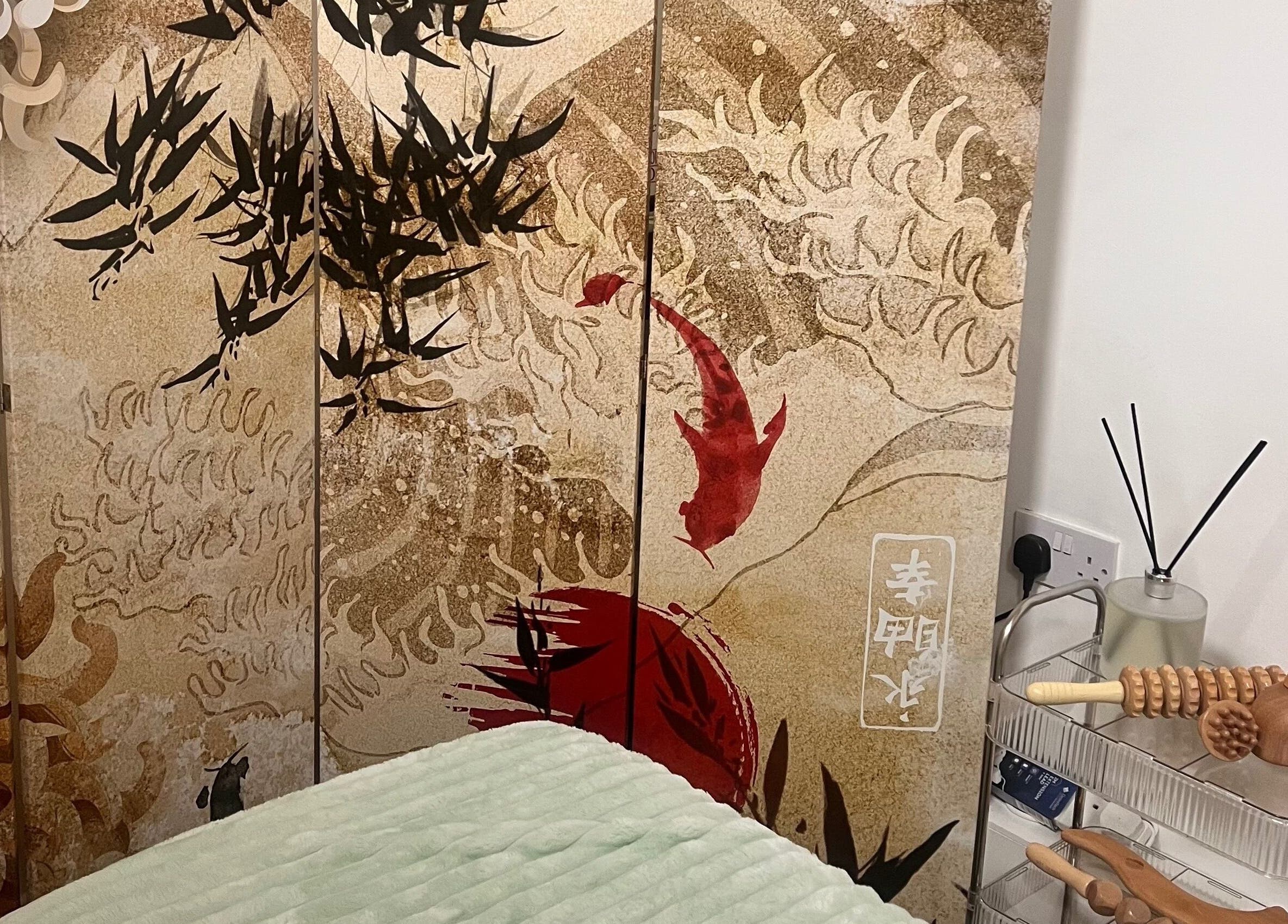 Serene Gaia Massage room decor in Harrow, England, GB with a calming oriental screen and wellness tools.