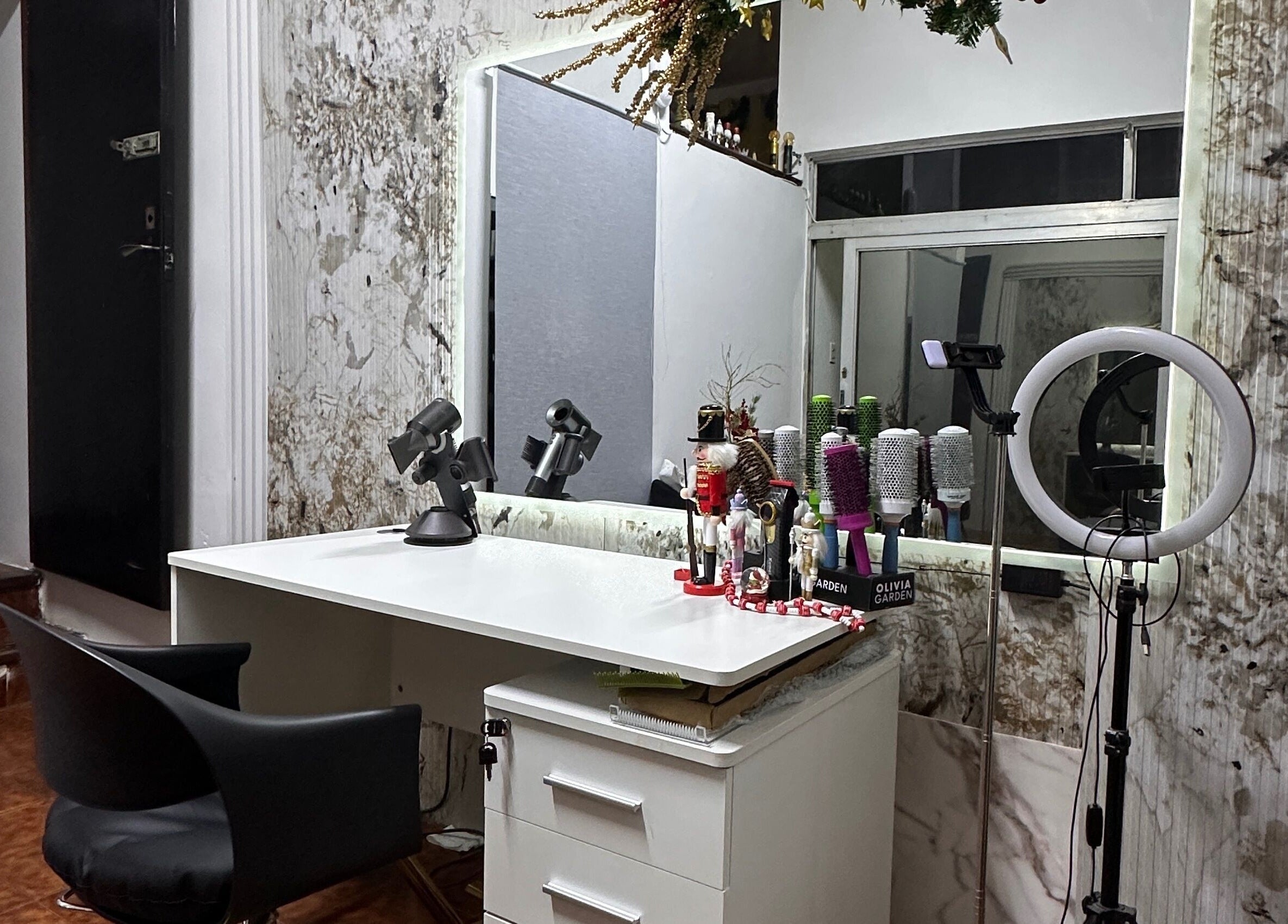 Estación de peinado en Delkys Hair Studio, Valencia, Carabobo, VE, con espejo y herramientas de estilismo.