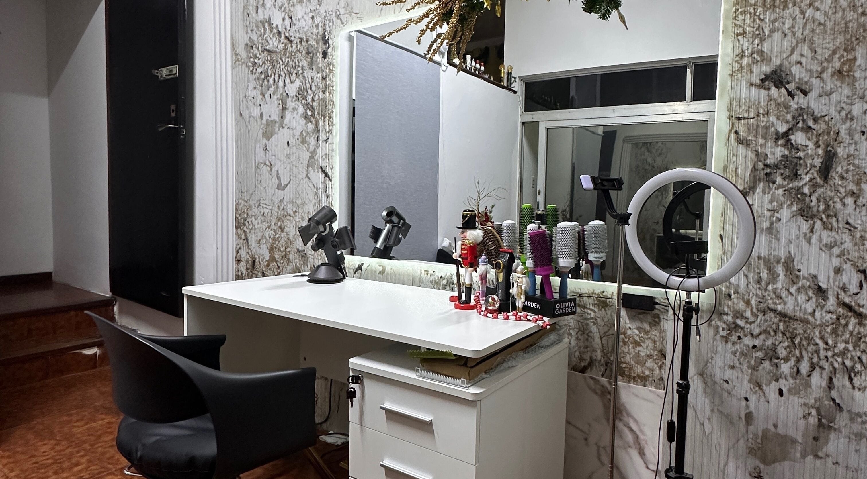 Estación de peinado en Delkys Hair Studio, Valencia, Carabobo, VE, con espejo y herramientas de estilismo.