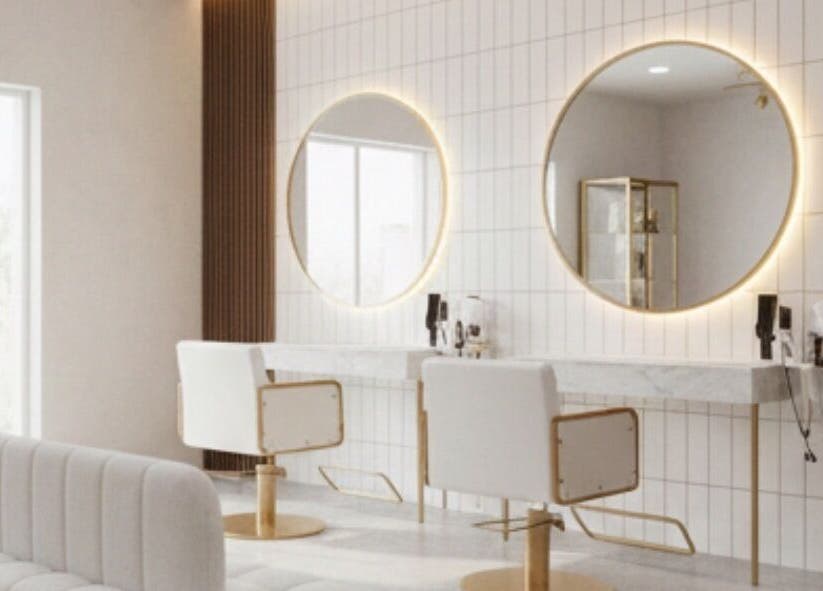 Modern salon at Dajore Hair in Freeport, BS, featuring illuminated mirrors and elegant styling chairs.
