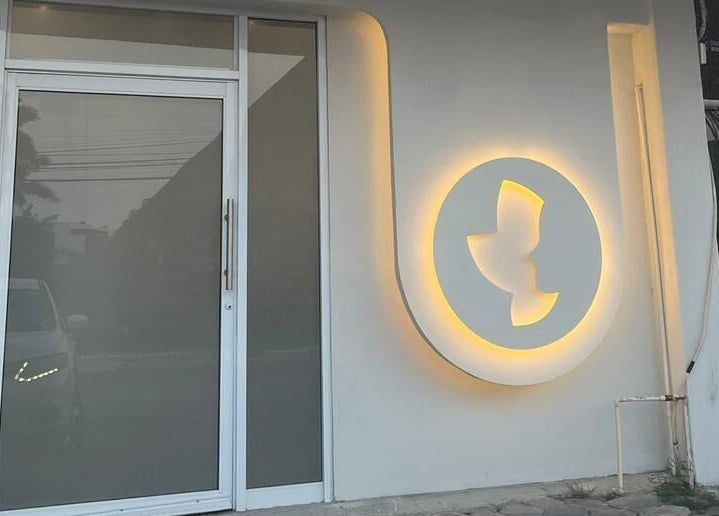 Entrada iluminada de Sunless Club en Tampico, Tamaulipas, MX, mostrando el logotipo en la pared.