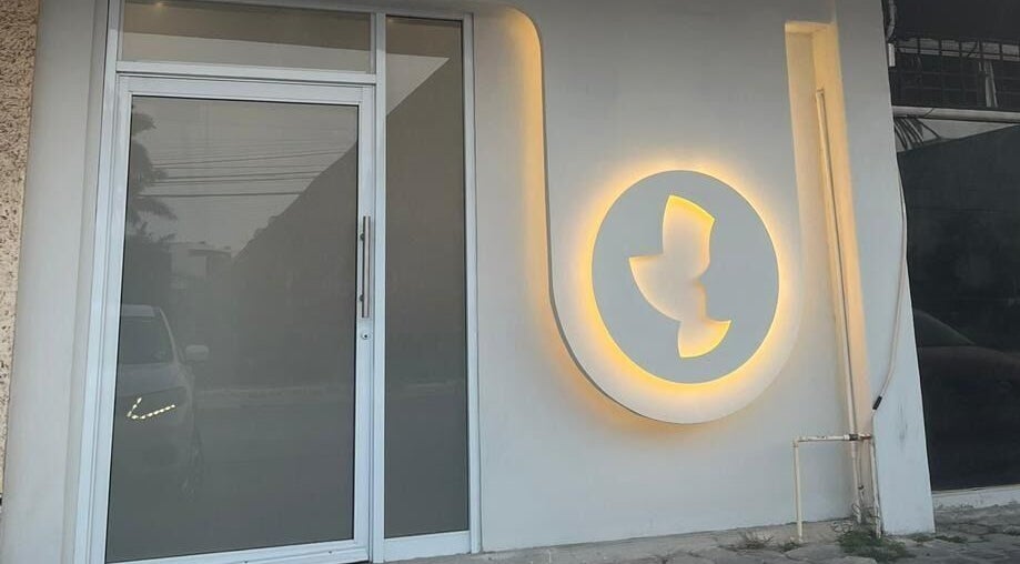 Entrada iluminada de Sunless Club en Tampico, Tamaulipas, MX, mostrando el logotipo en la pared.