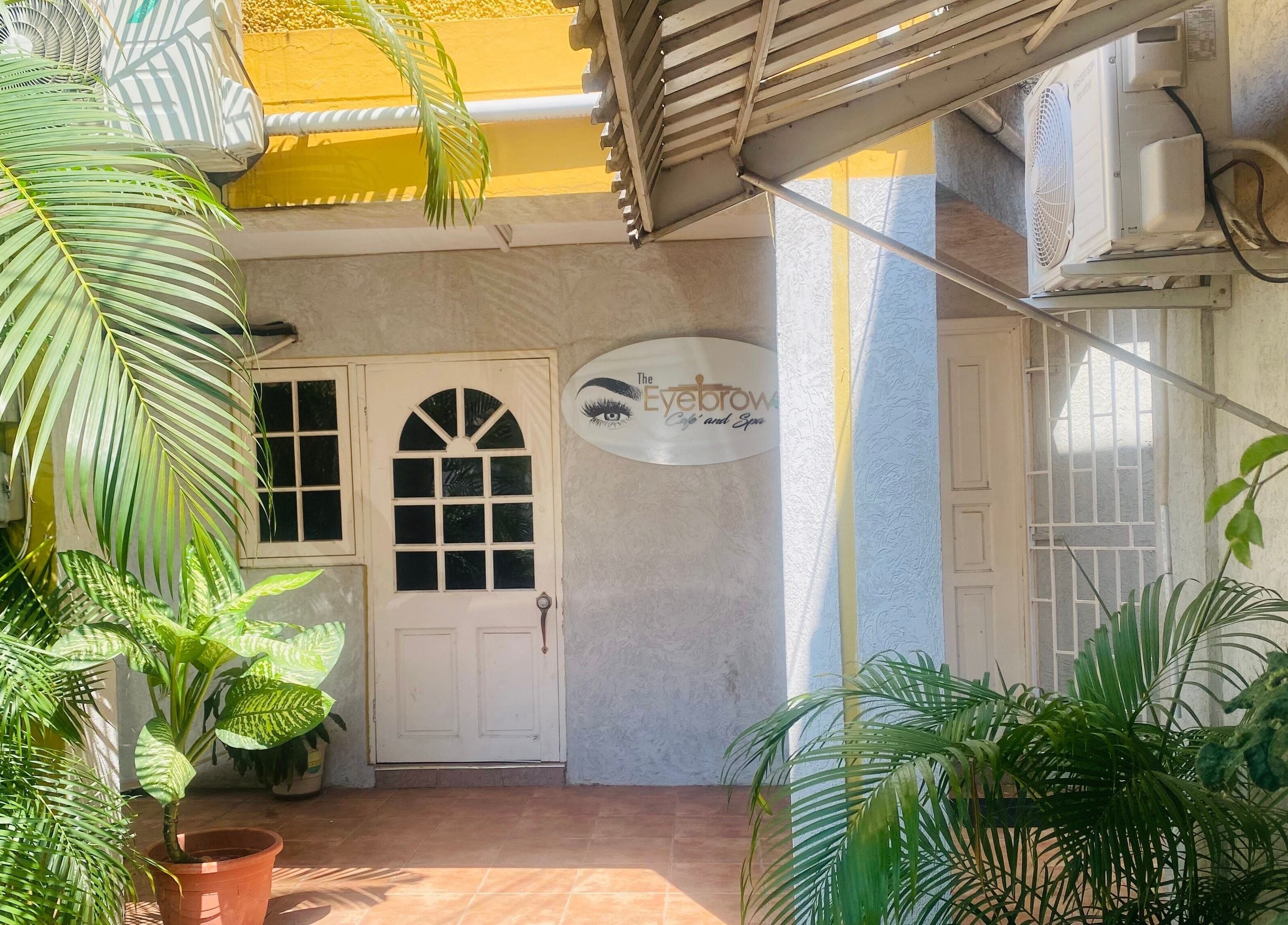 Entrance to Healing Emerald Wellness Spa & Training Centre Ltd, Kingston, St. Andrew Parish, with lush greenery.