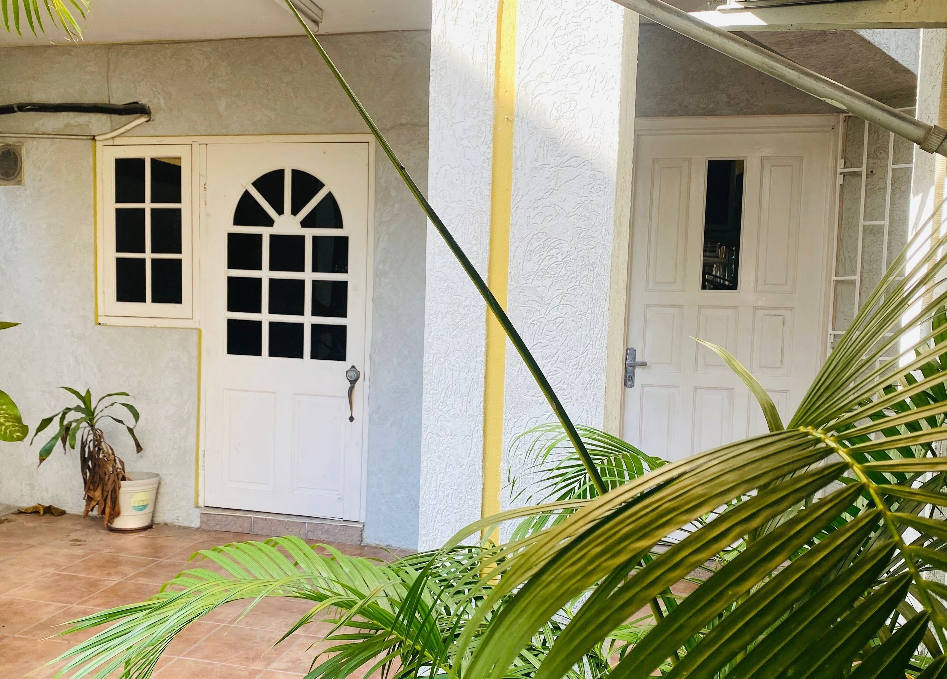 Entrance of Healing Emerald Wellness Spa & Training Centre Ltd in Kingston, St. Andrew Parish, JM with lush plants.