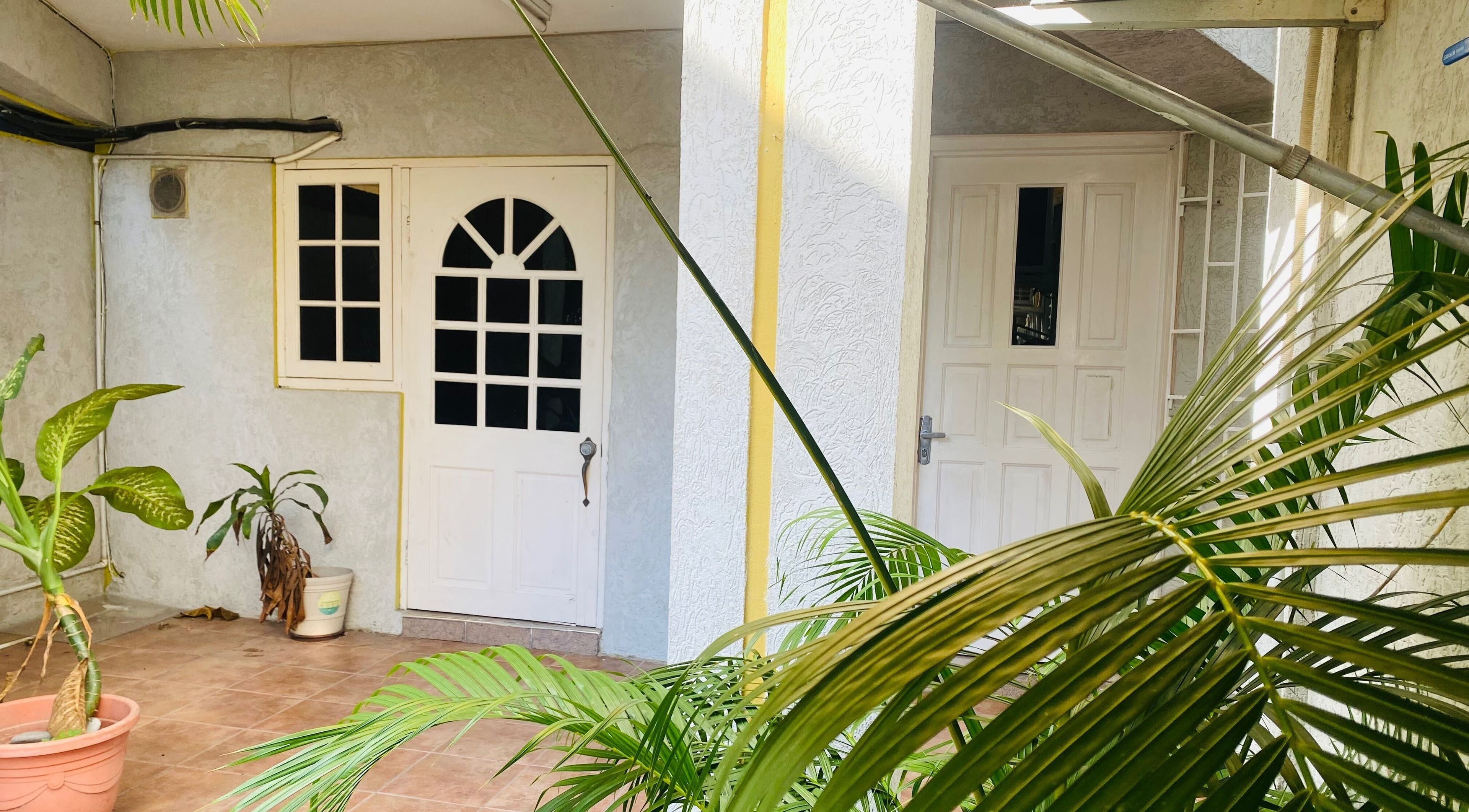 Entrance of Healing Emerald Wellness Spa & Training Centre Ltd in Kingston, St. Andrew Parish, JM with lush plants.