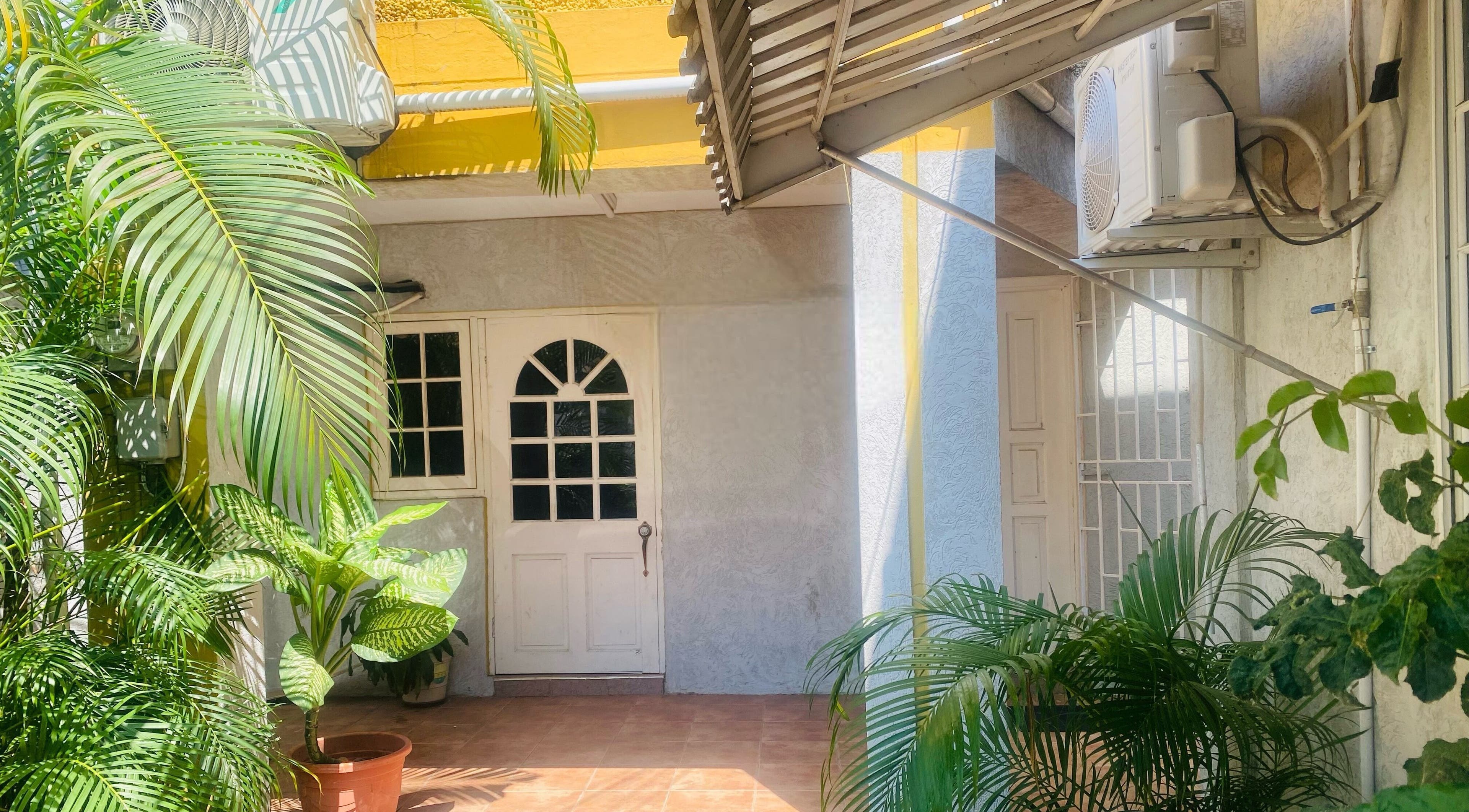 Healing Emerald Wellness Spa entrance with lush plants in Kingston, St. Andrew Parish, JM.