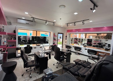 Interior moderno de Aldo's Salon en Panamá, Panamá, PA, con estaciones de belleza y sillas cómodas.