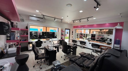 Interior moderno de Aldo's Salon en Panamá, Panamá, PA, con estaciones de belleza y sillas cómodas.