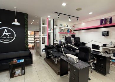 Interior moderno de Aldo's Salon en Panamá, Panamá, PA, con estaciones de peluquería y productos de belleza.