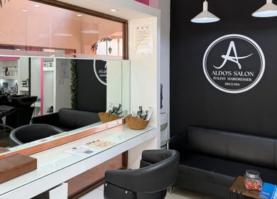 Interior moderno de Aldo's Salon en Panamá, Panamá, PA, con espejos amplios y asientos elegantes.