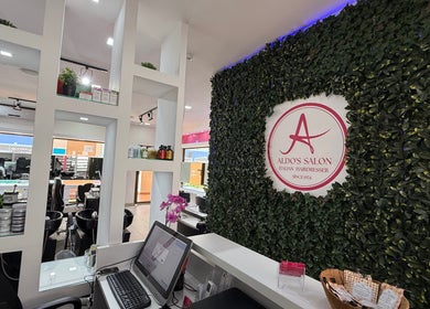 Recepción de Aldo's Salon en Panamá, Panamá, PA con decoración verde y productos de belleza.