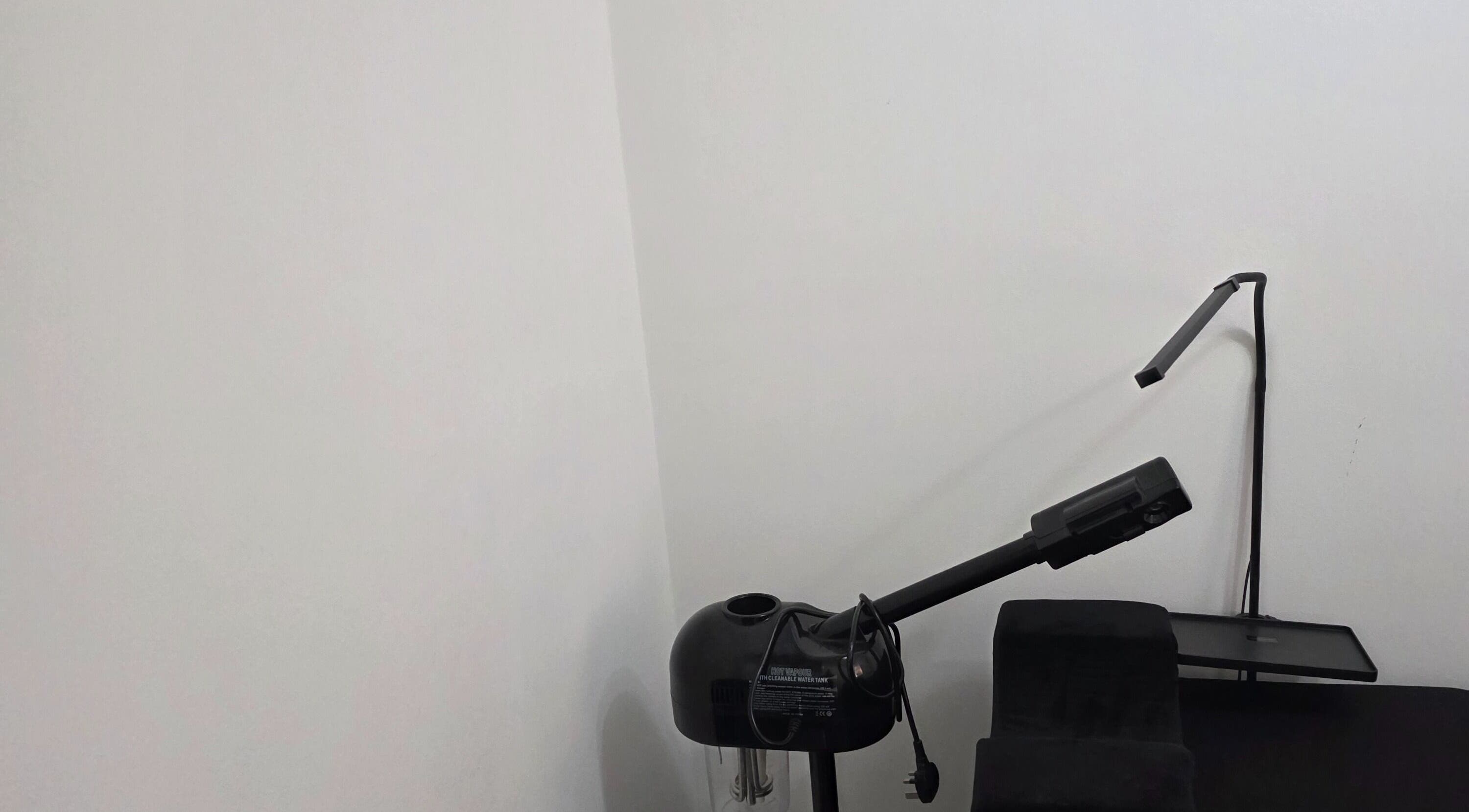 Minimalist skincare setup at Ink and Indulgence, Liverpool, England, GB featuring sleek black equipment.