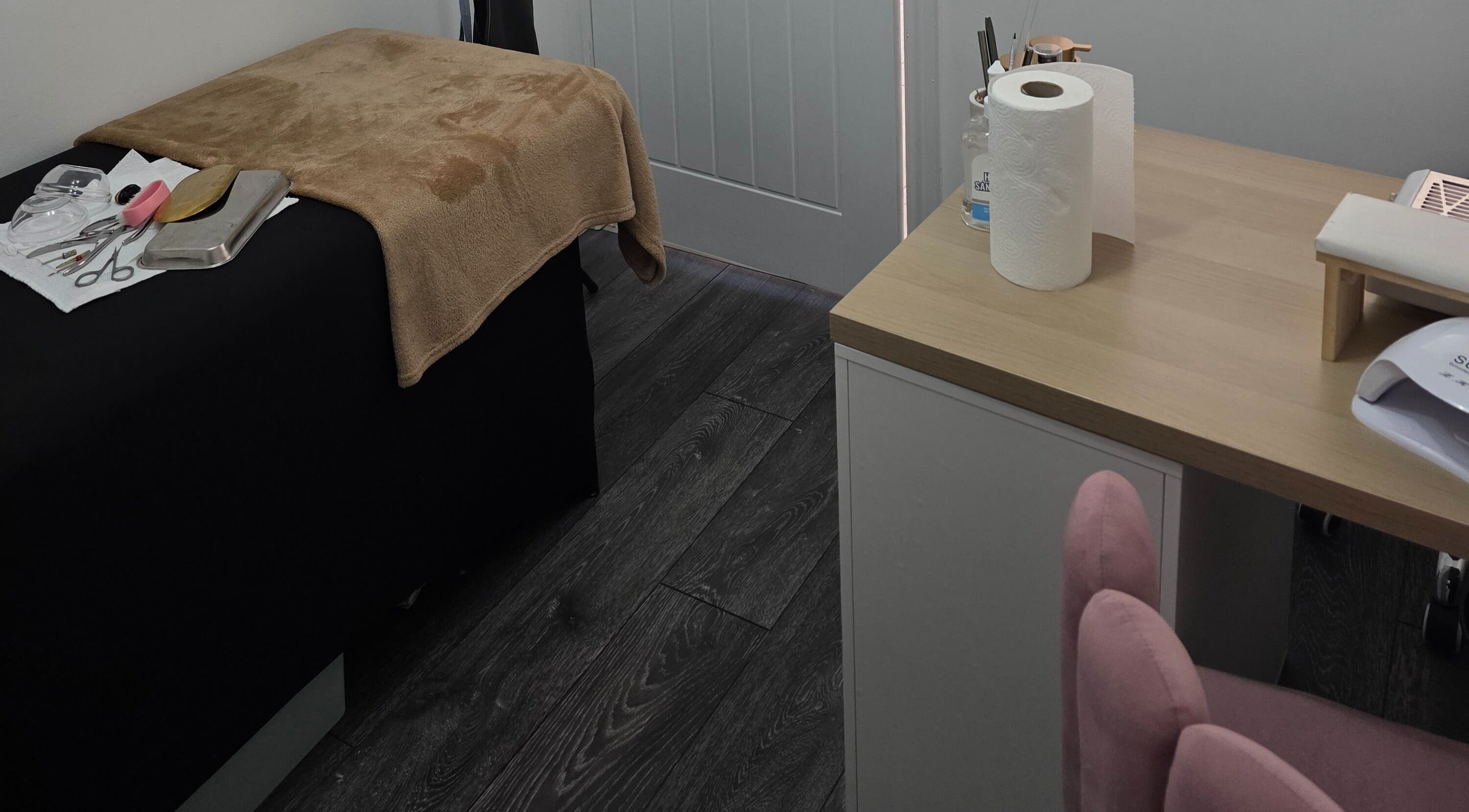 Cozy beauty treatment room at Ink and Indulgence, Liverpool, England, GB, featuring tools and a comfy bed.