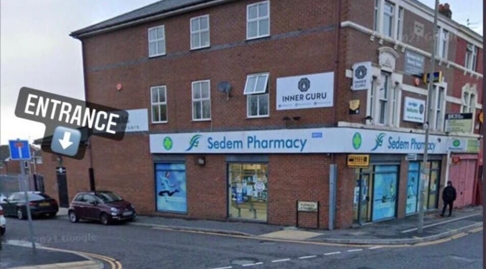 Entrance to Ink and Indulgence on a lively street corner in Liverpool, England, GB, above Sedem Pharmacy.