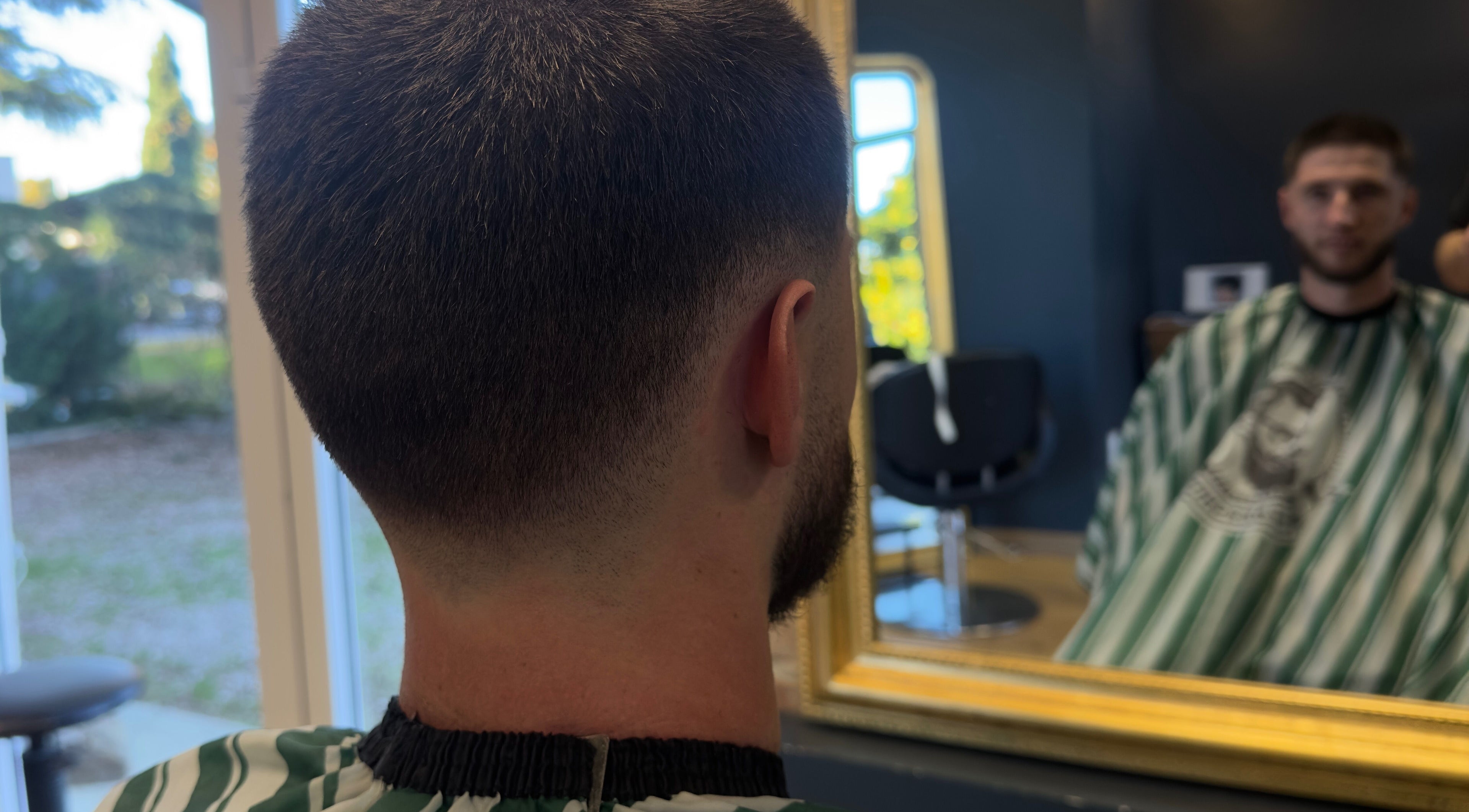 Homme regardant sa nouvelle coupe au salon Pito.cld, Noé, Occitanie, FR. Style moderne et soigné.