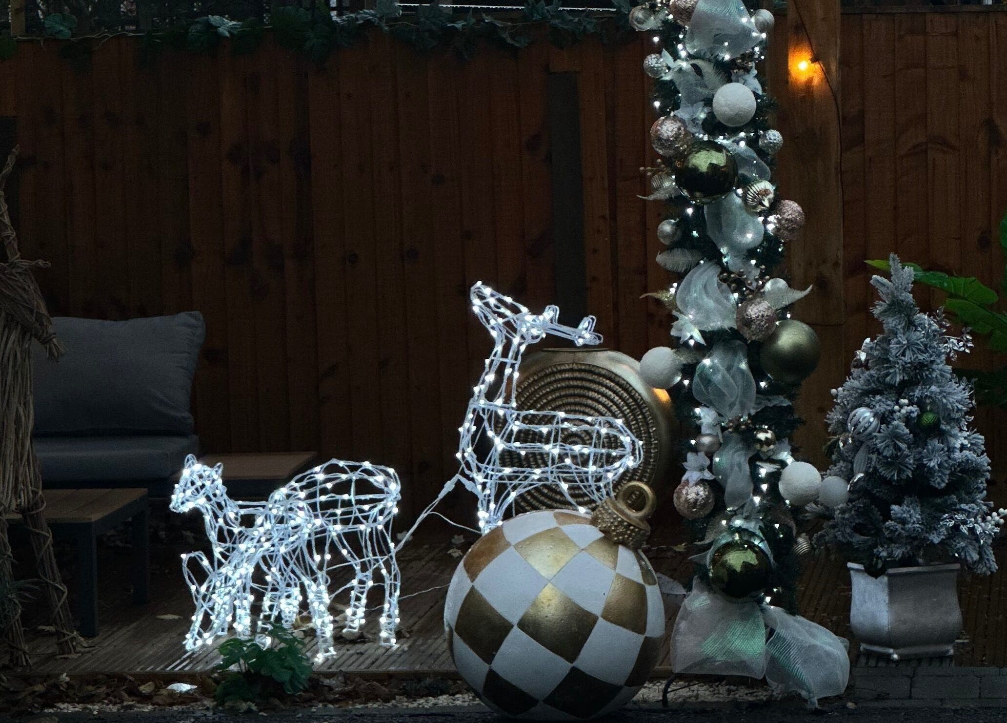 Cozy outdoor festive decor at The Nail Haven, Nottingham, England, GB, featuring lit reindeer and ornaments.