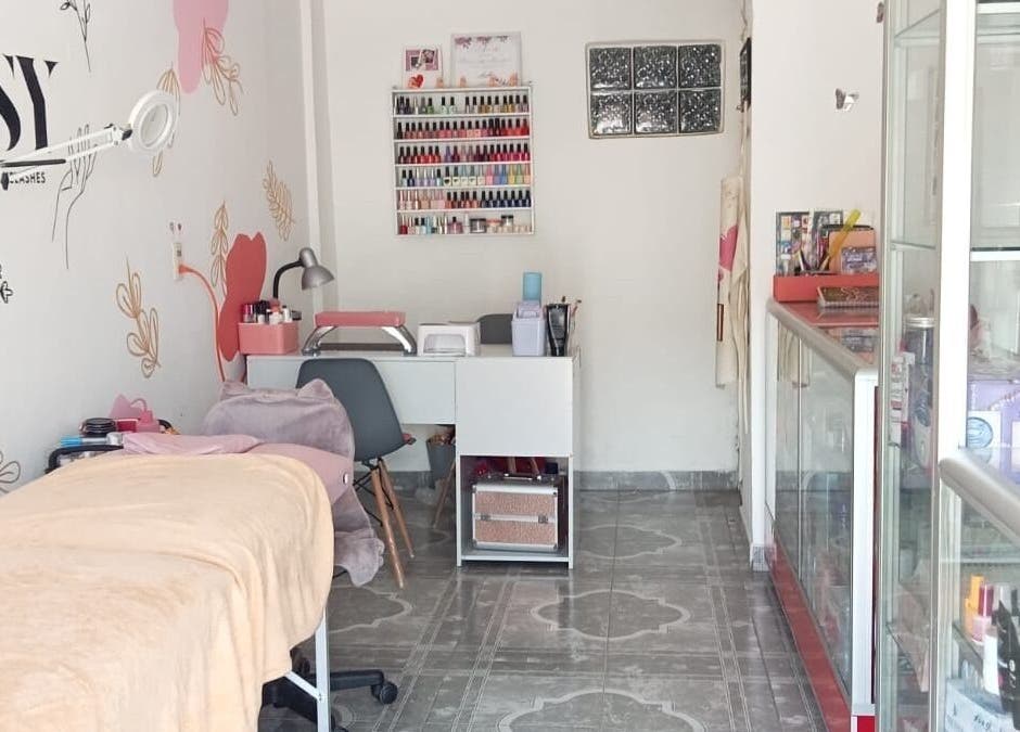 Interior de YSY Estudio en Fuentes Del Valle, Estado De México, MX con camilla y estante de esmaltes.