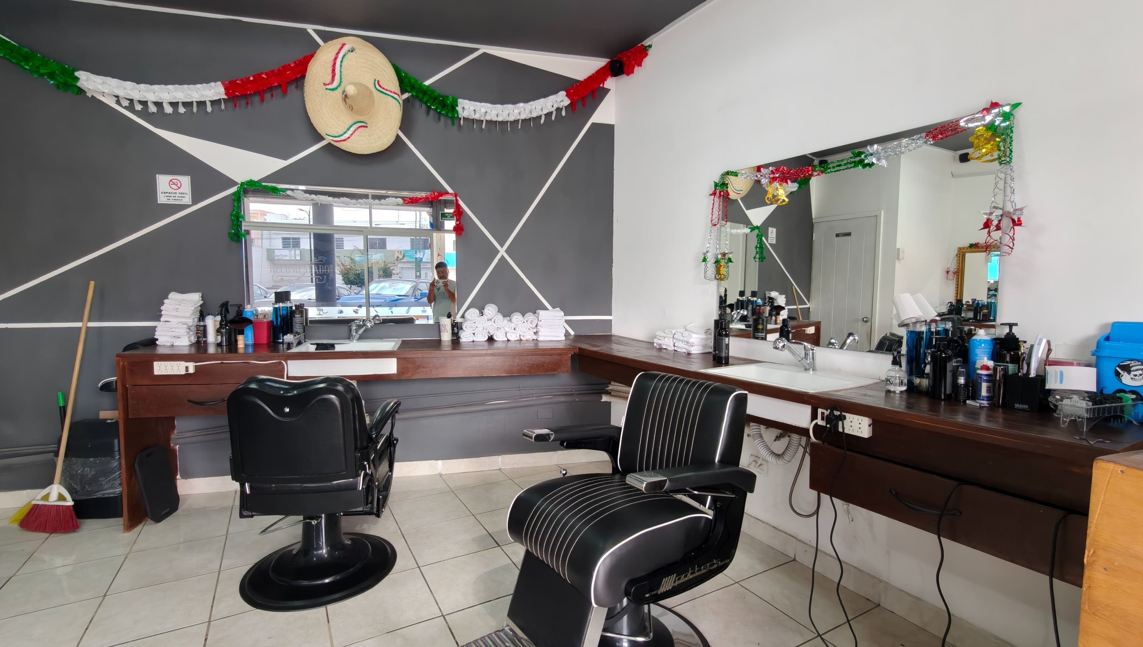 Interior decorado de Barberia El Recomendado en CORREGIDORA, Querétaro, MX con sillas y espejos elegantes.