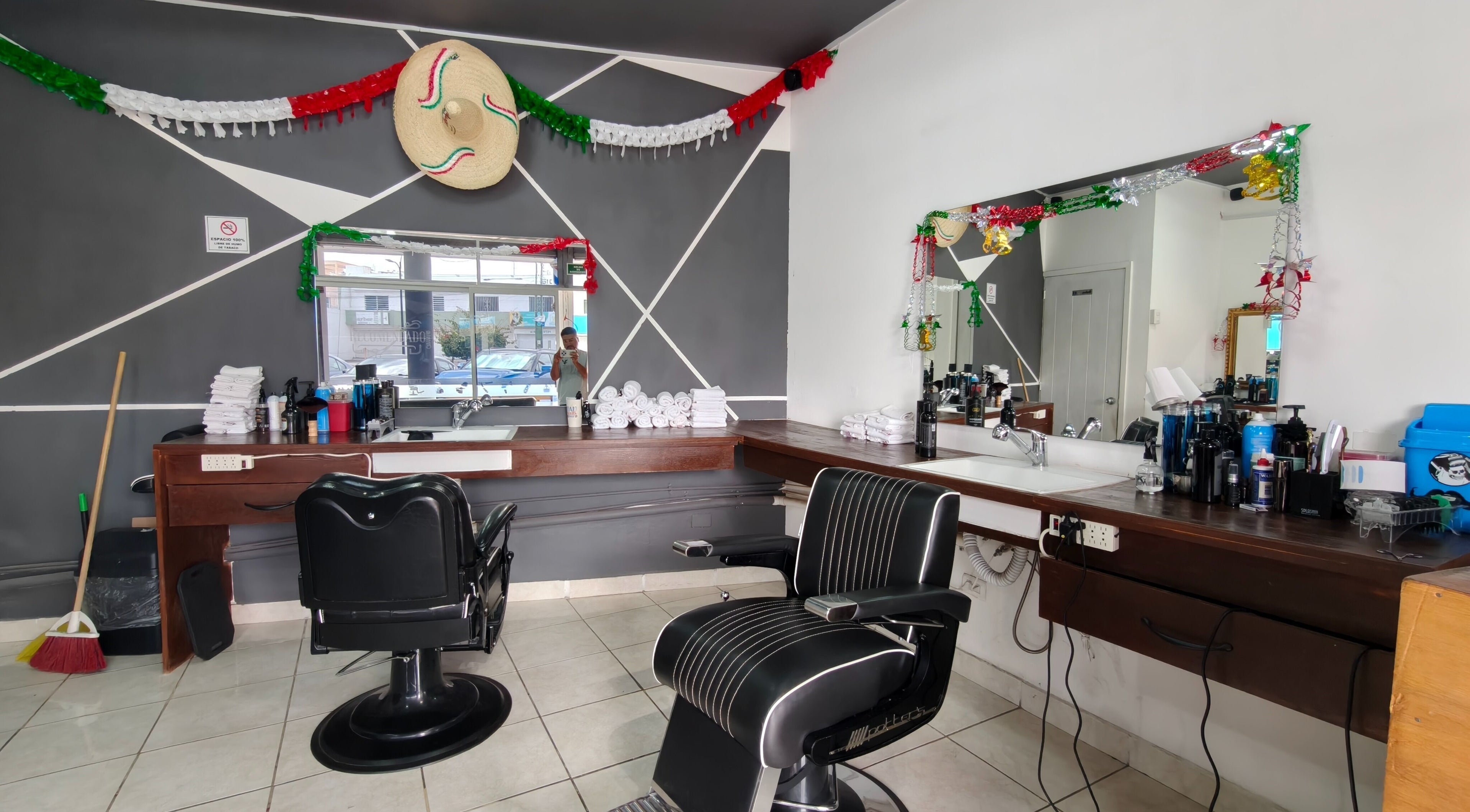 Interior decorado de Barberia El Recomendado en CORREGIDORA, Querétaro, MX con sillas y espejos elegantes.