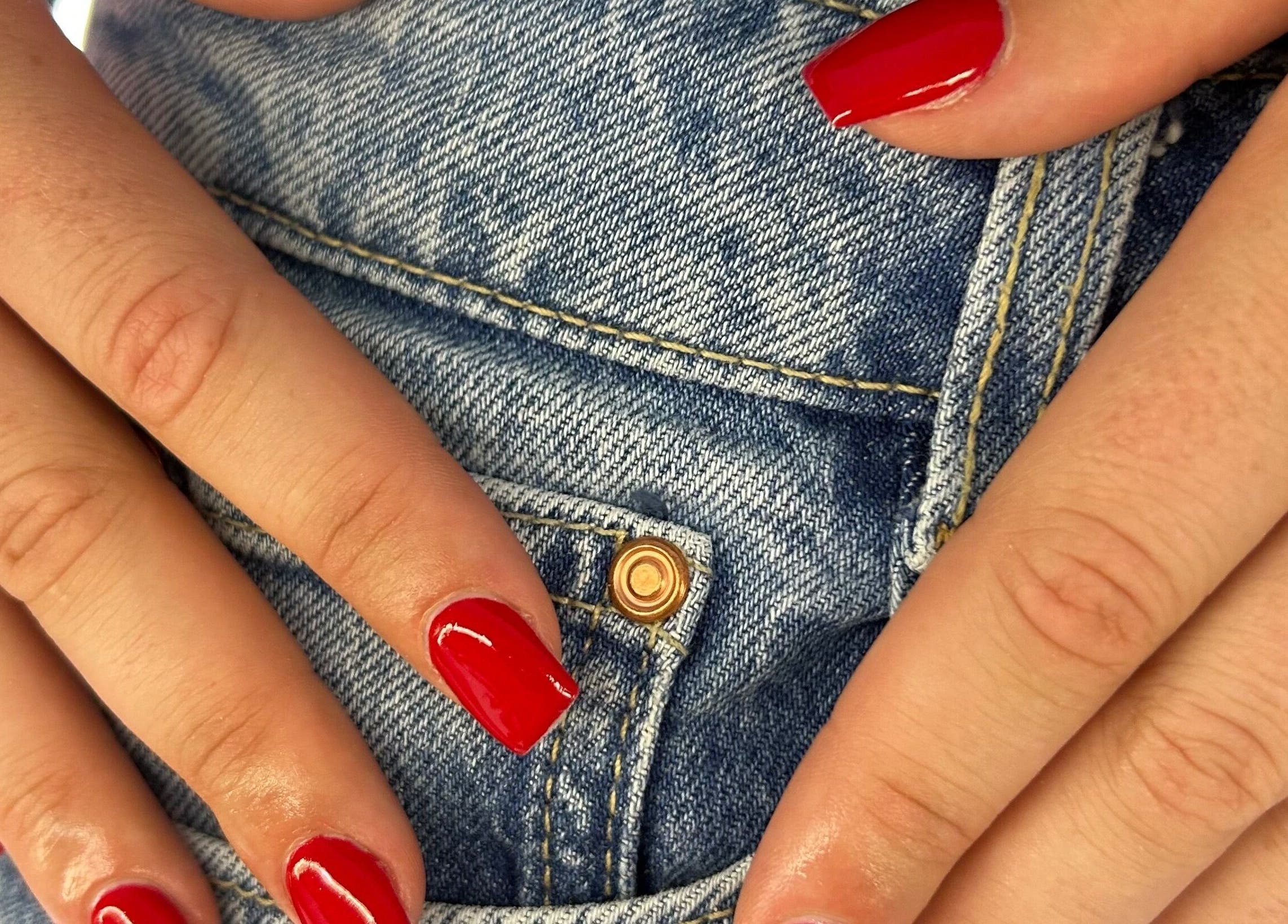 Manucure rouge éclatante à Écrin d’ambrya, Restinclières, Occitanie, FR avec fond denim.