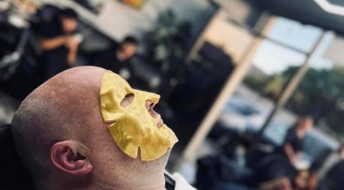 Client enjoys a rejuvenating gold facial mask at Romeros Barber Studio, Tijuana, Baja California, MX.