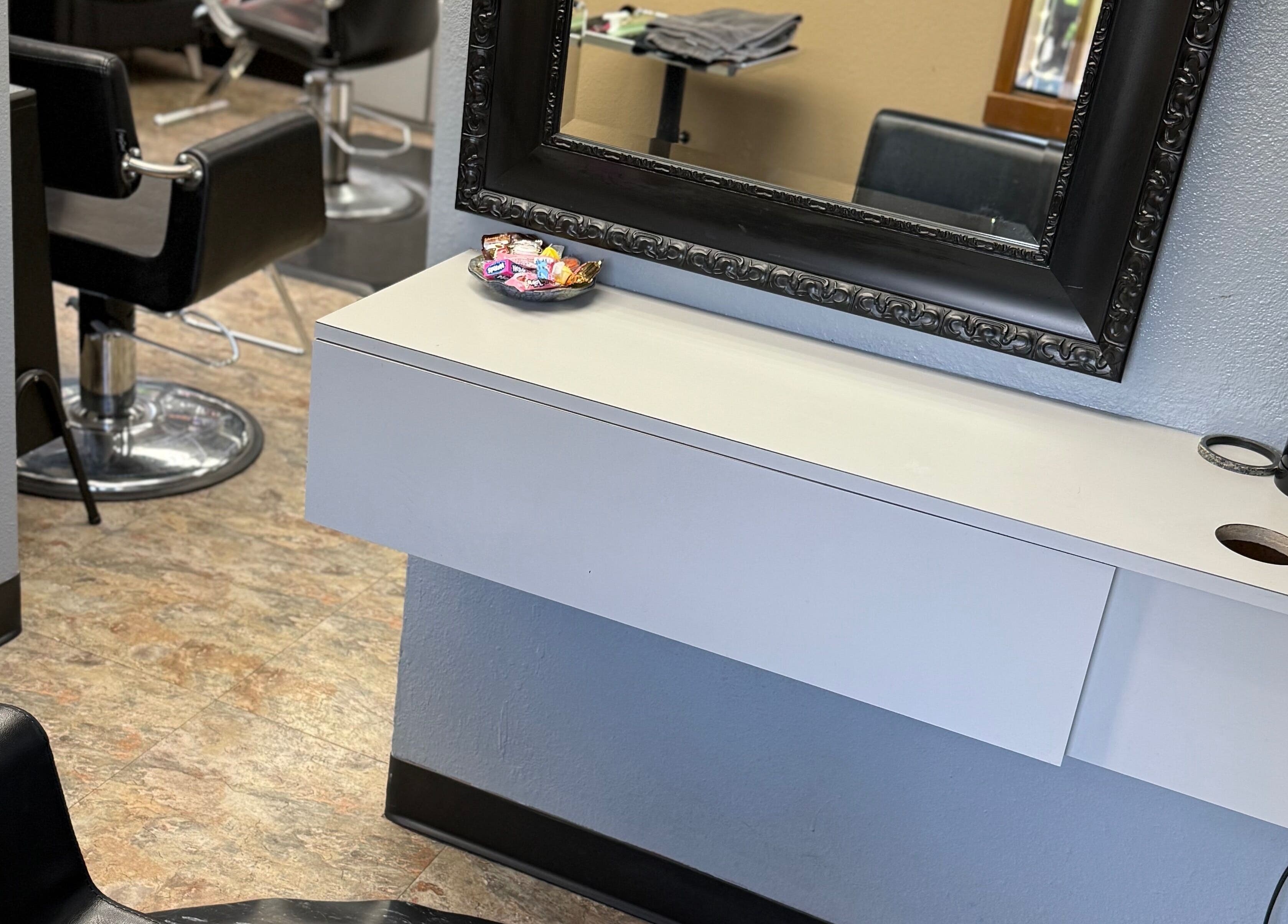 Abrianna Kelly salon station with black chairs and ornate mirror in Everett, Washington, US.