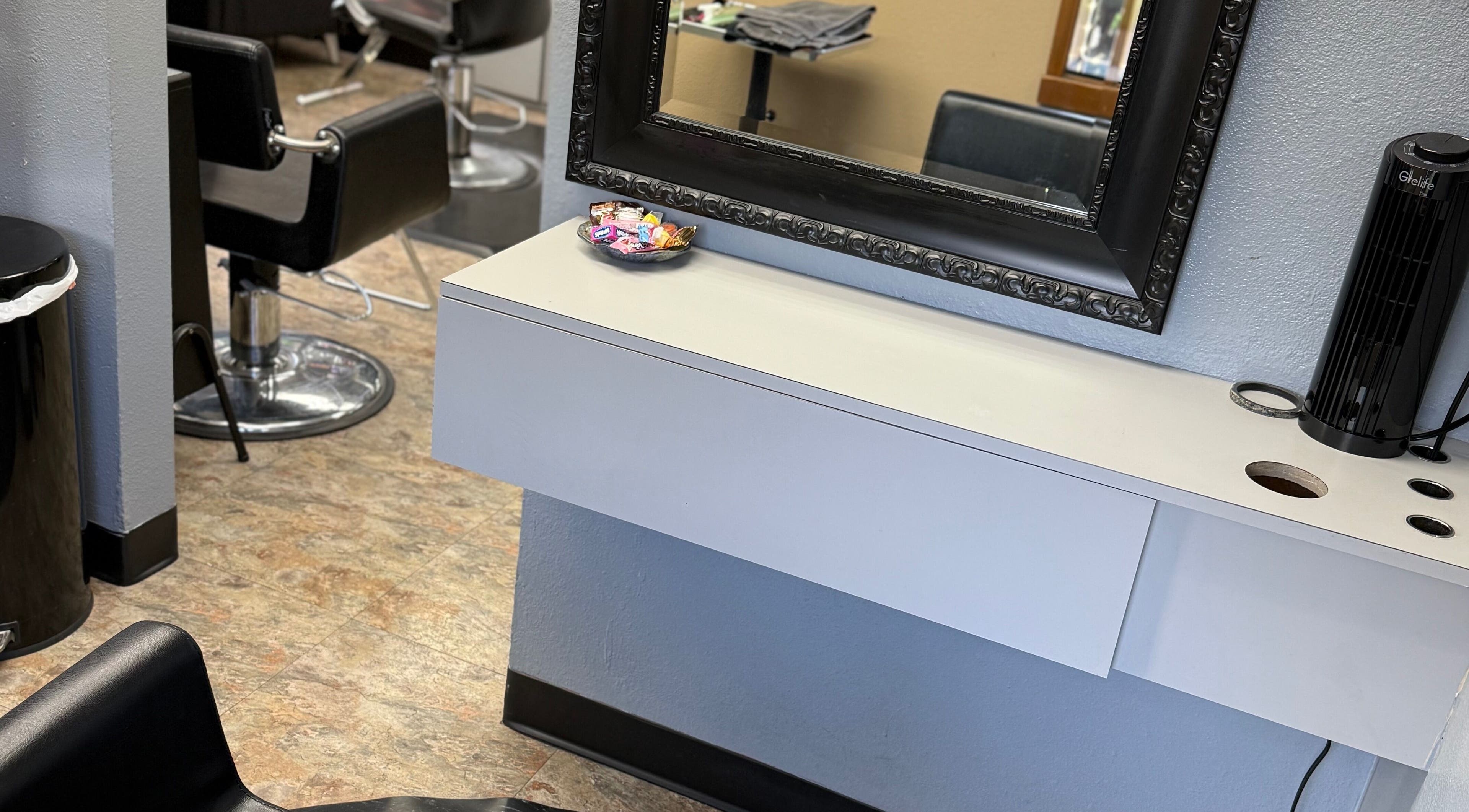 Abrianna Kelly salon station with black chairs and ornate mirror in Everett, Washington, US.