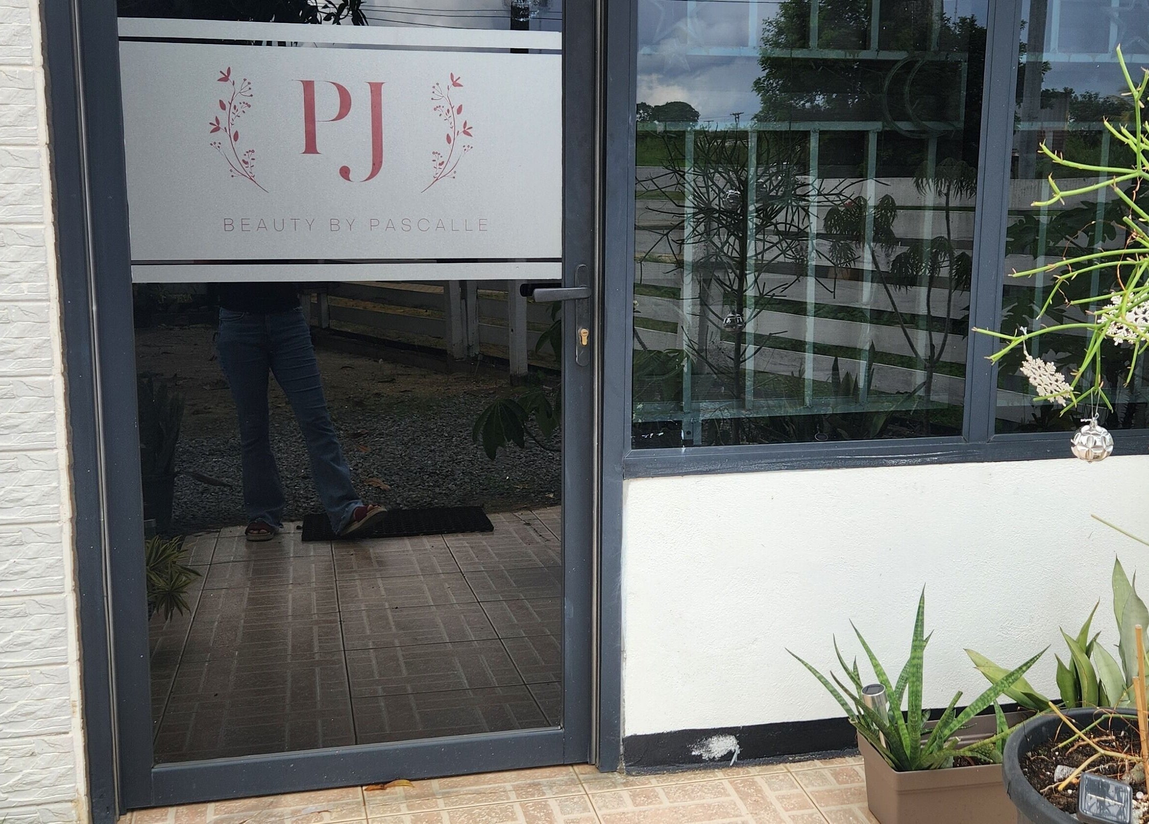 Entrance of Beauty by Pascalle, Paramaribo Noord, SR, featuring elegant signage and potted plants.