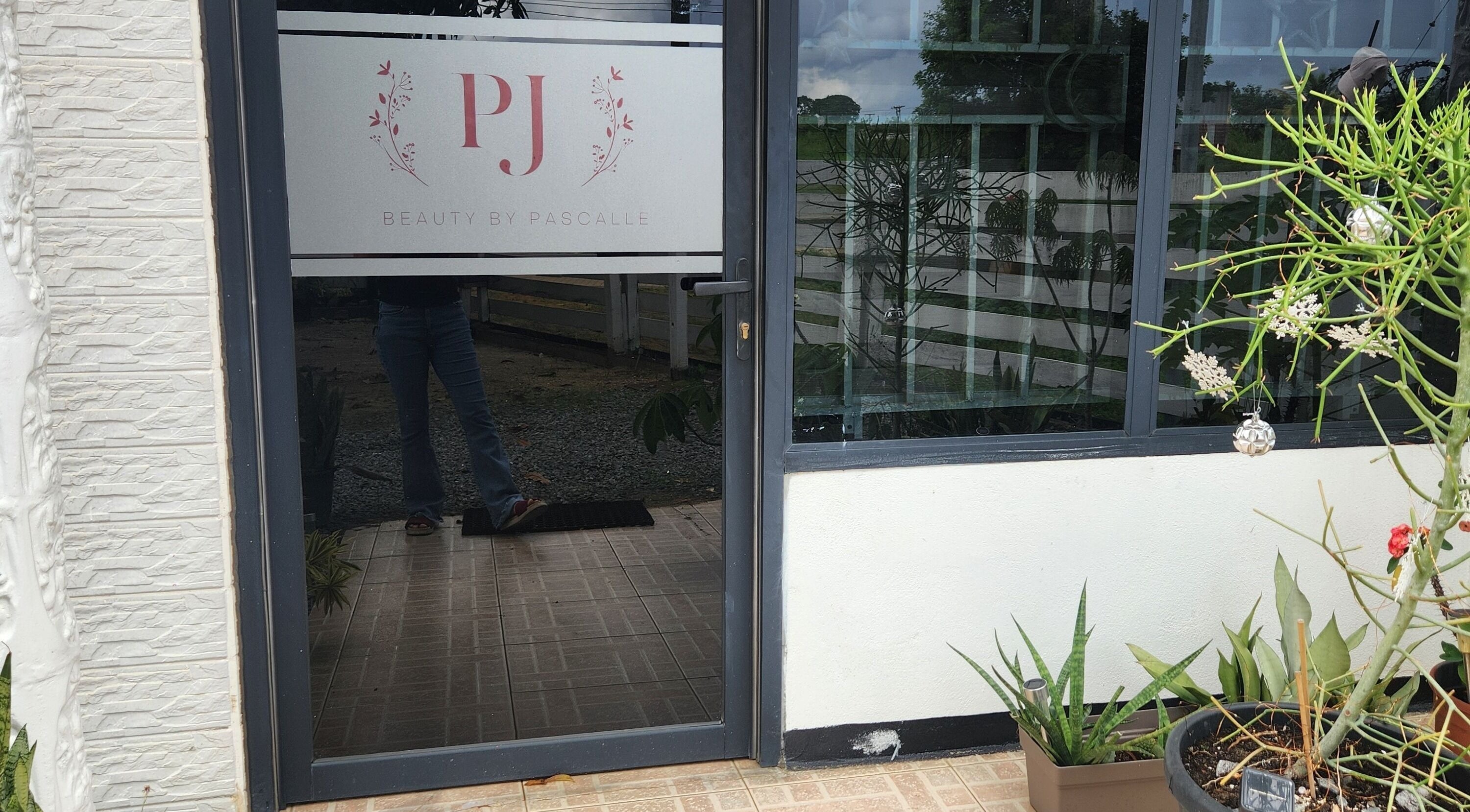 Entrance of Beauty by Pascalle, Paramaribo Noord, SR, featuring elegant signage and potted plants.