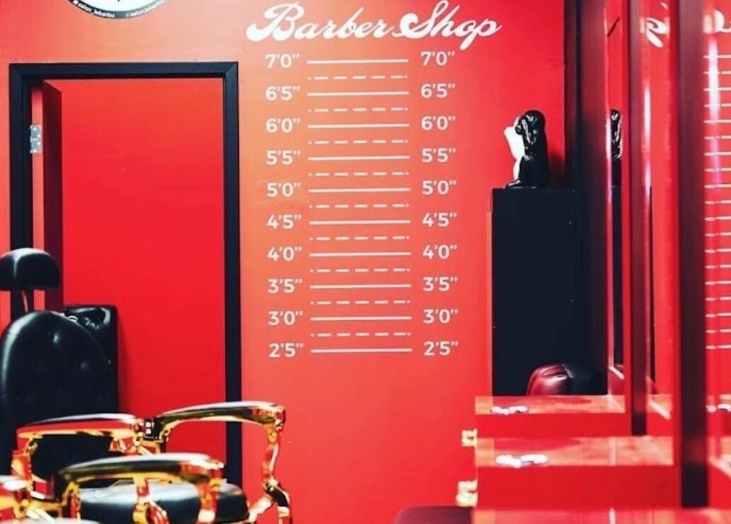Sleek barber shop interior at Le Barbu Henri-Bourassa, Montréal, Québec, CA with vibrant red decor.