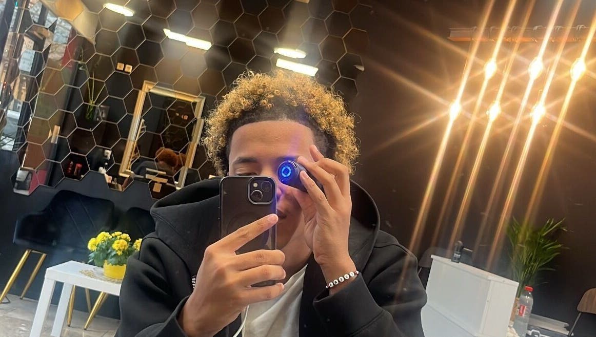 Client at Tstar.The.Barber, Dudelange, with chic interior and glowing lights.