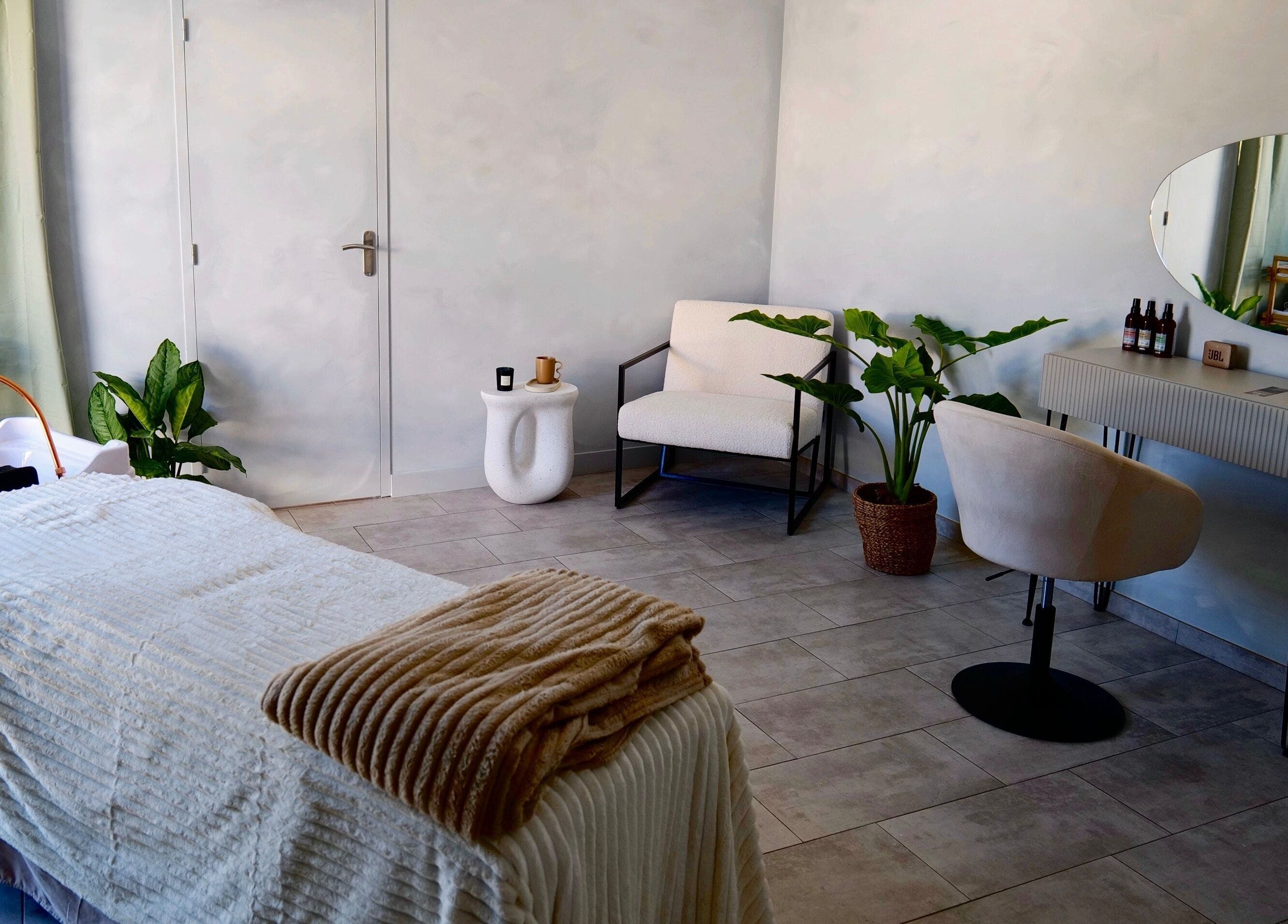 Salle de soins relaxante à Enea Head Spa, Bidart, Nouvelle-Aquitaine, FR, avec lit de massage et plantes apaisantes.