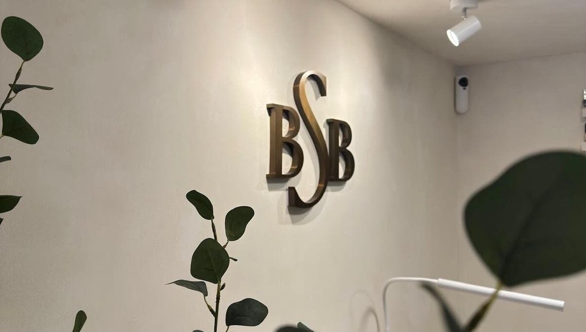 Elegant BSB logo on wall at Brazilian Soul Beauty, London, England, GB surrounded by greenery.