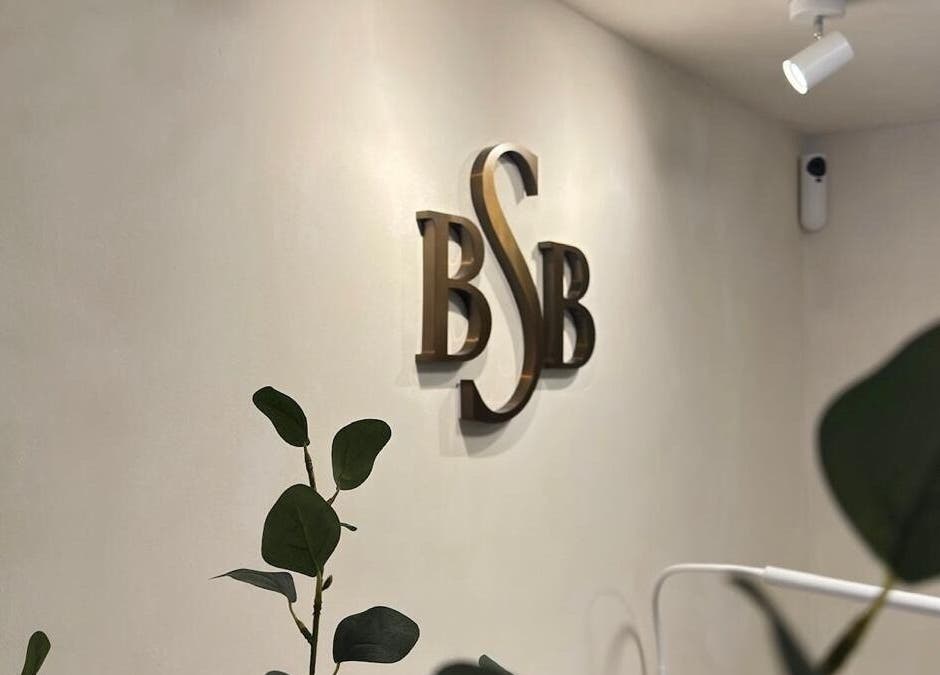 Elegant BSB logo on wall at Brazilian Soul Beauty, London, England, GB surrounded by greenery.