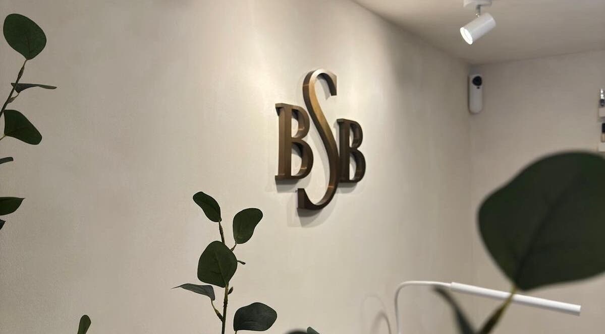 Elegant BSB logo on wall at Brazilian Soul Beauty, London, England, GB surrounded by greenery.