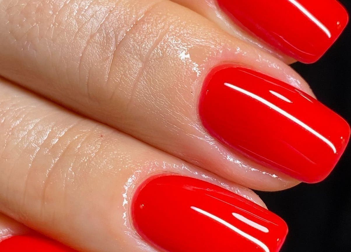 Vibrant red manicure at Brazilian Soul Beauty in London, England, GB shown on a hand with a glossy finish.