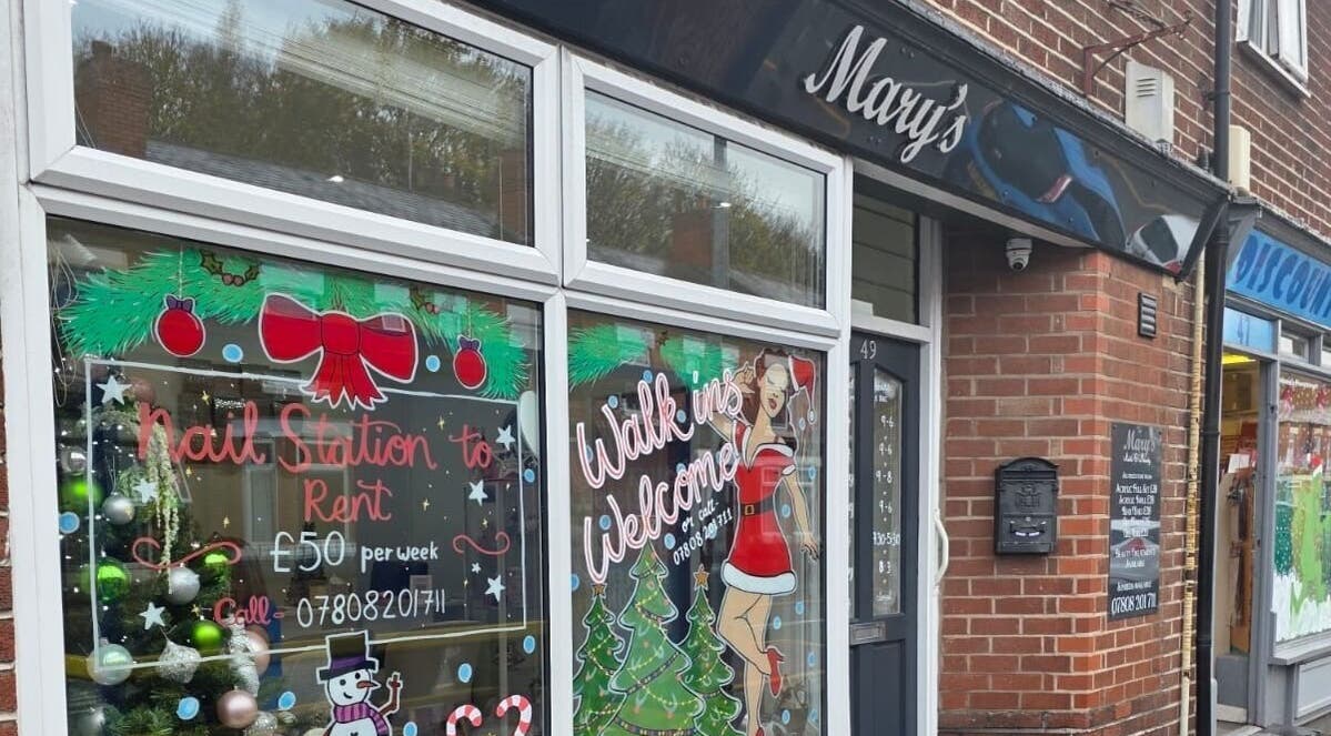 Front view of V Beauty World Ltd in Warrington, England, GB with festive window decorations.