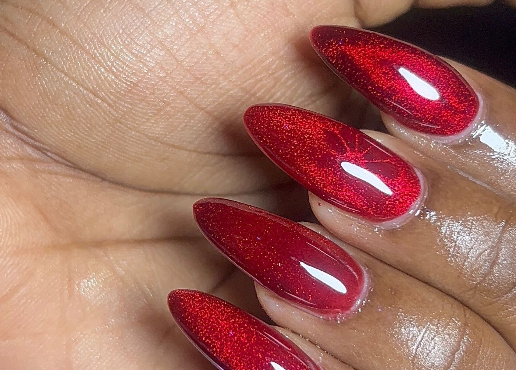Glossy red nails at DEAREST BEAUTY STUDIO, Lagos, NG, showcasing exquisite nail art detail.