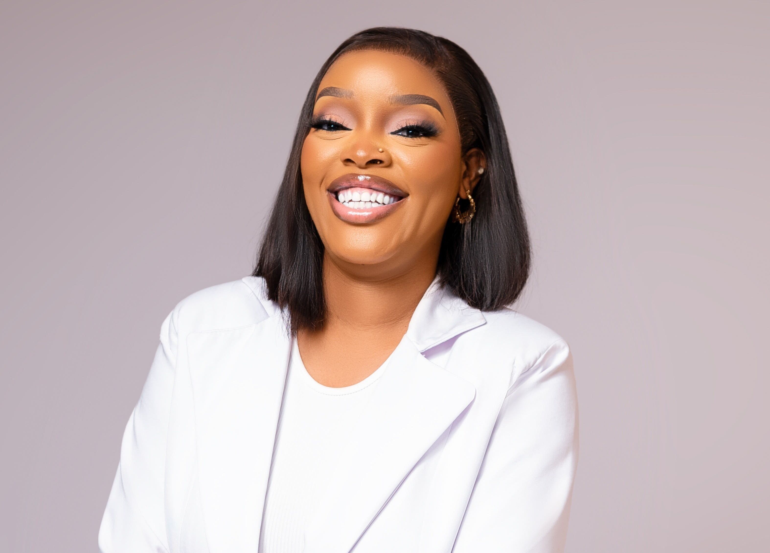 Professional at DEAREST BEAUTY STUDIO, Lagos, with a radiant smile and impeccable makeup.