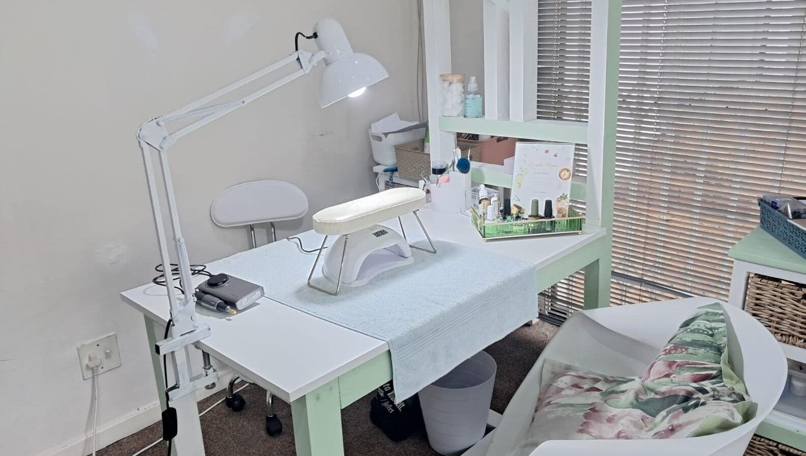 Nail treatment station at JC Petal and Polish, Cape Town, Western Cape, ZA, featuring tools and cozy seating.