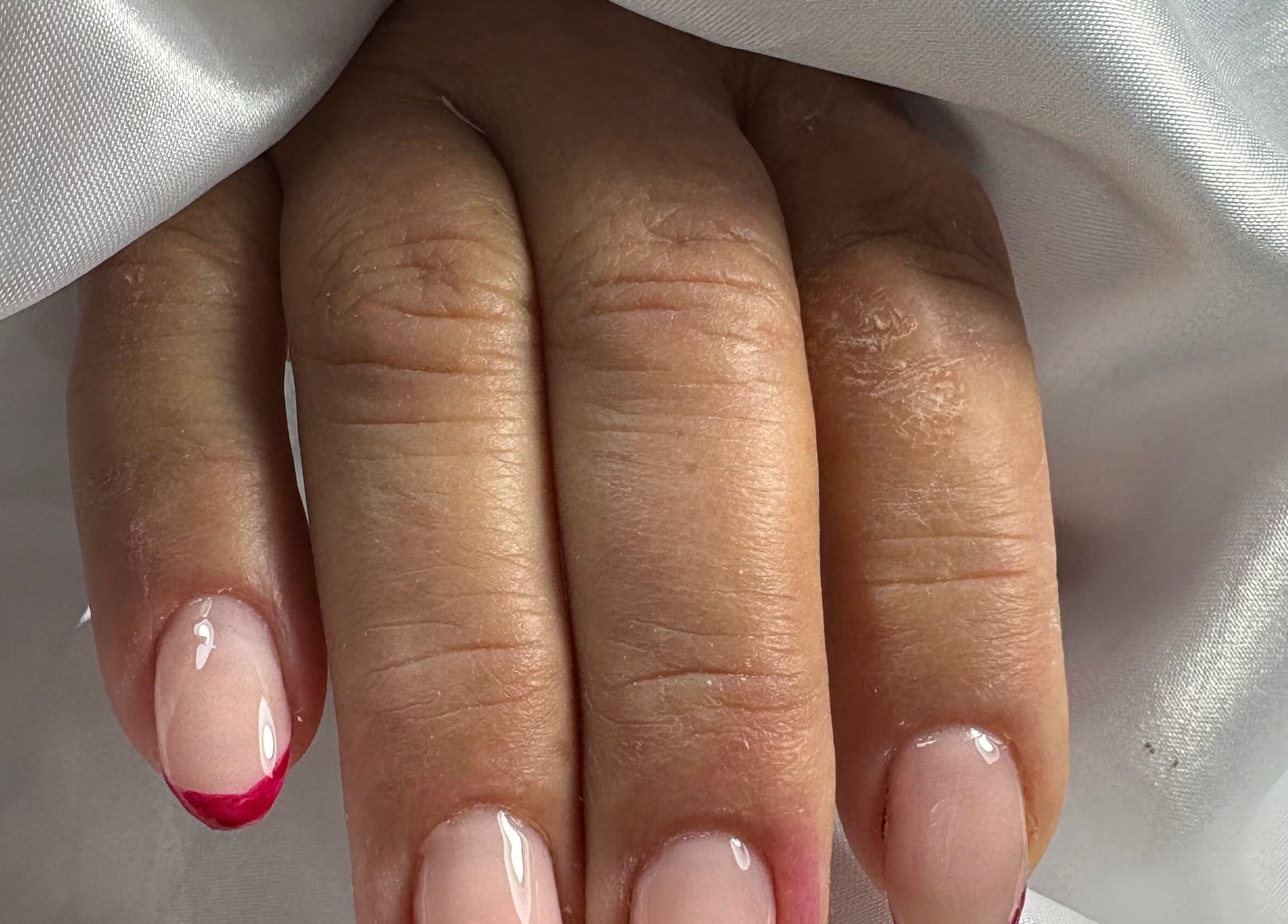 Stylish pink manicure with red tips at Nails By Carolina, PT.