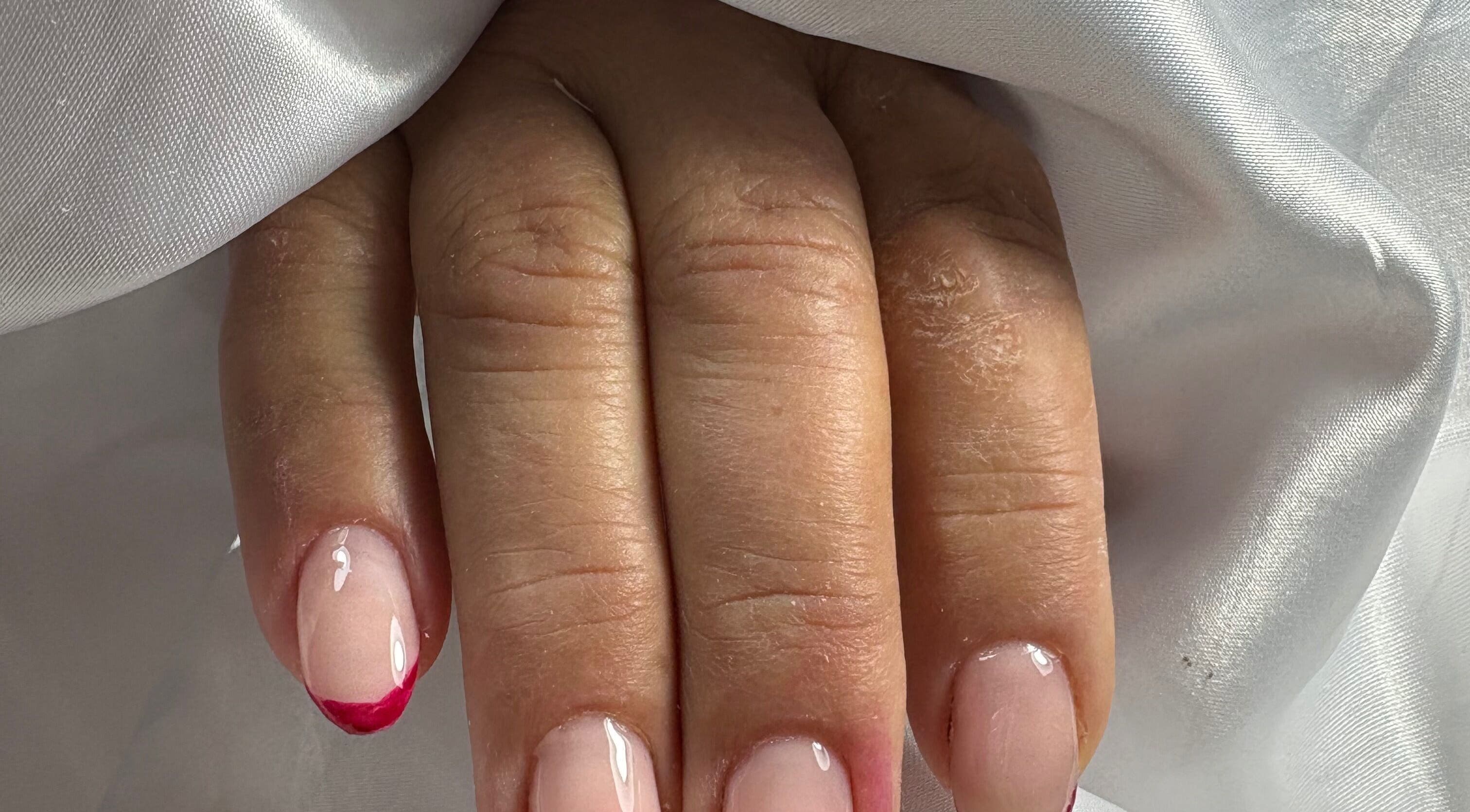 Stylish pink manicure with red tips at Nails By Carolina, PT.