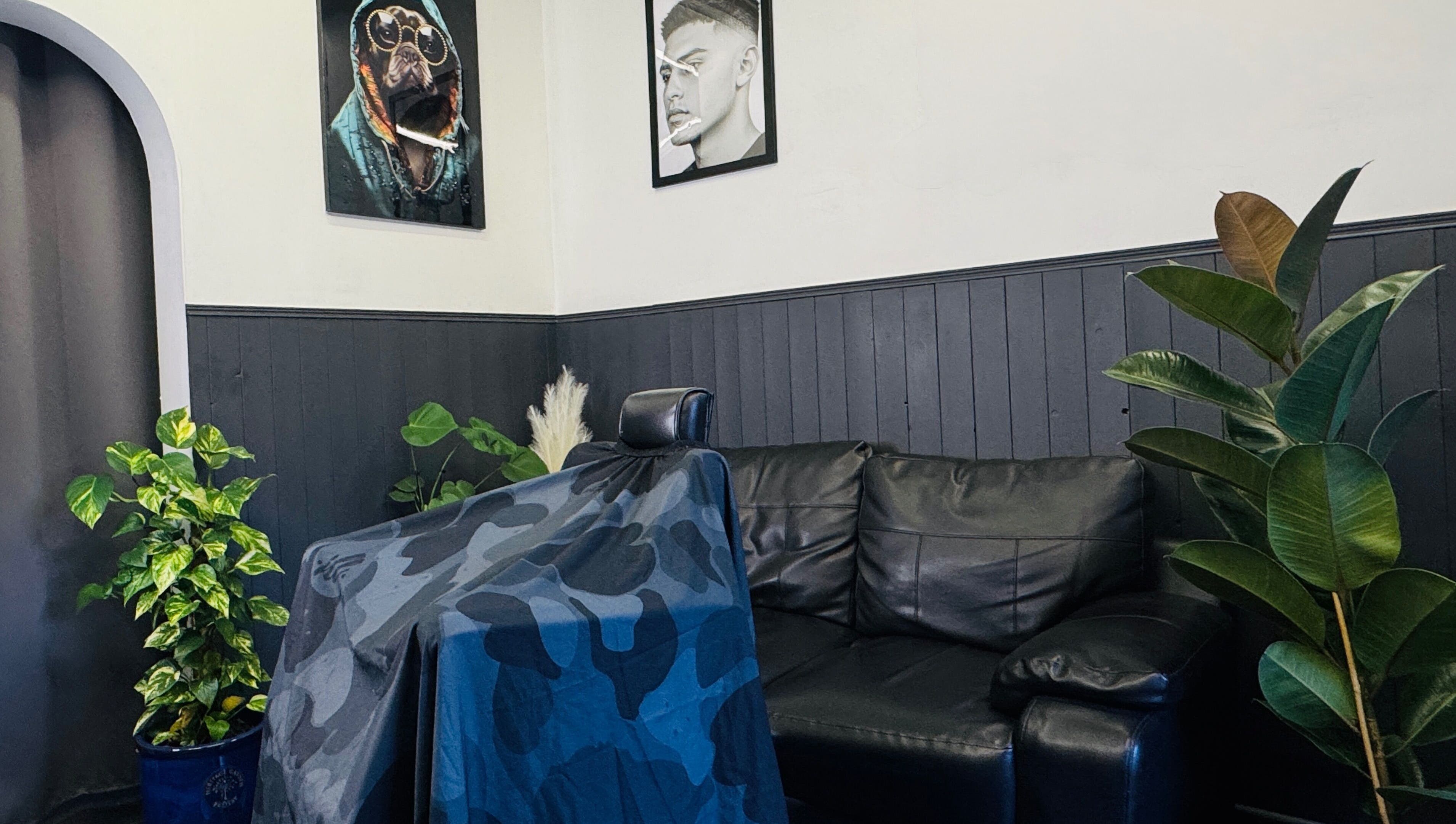 Chic interior of GavBarber in Darwen, England, GB featuring leather seating, vibrant plants, and modern decor.